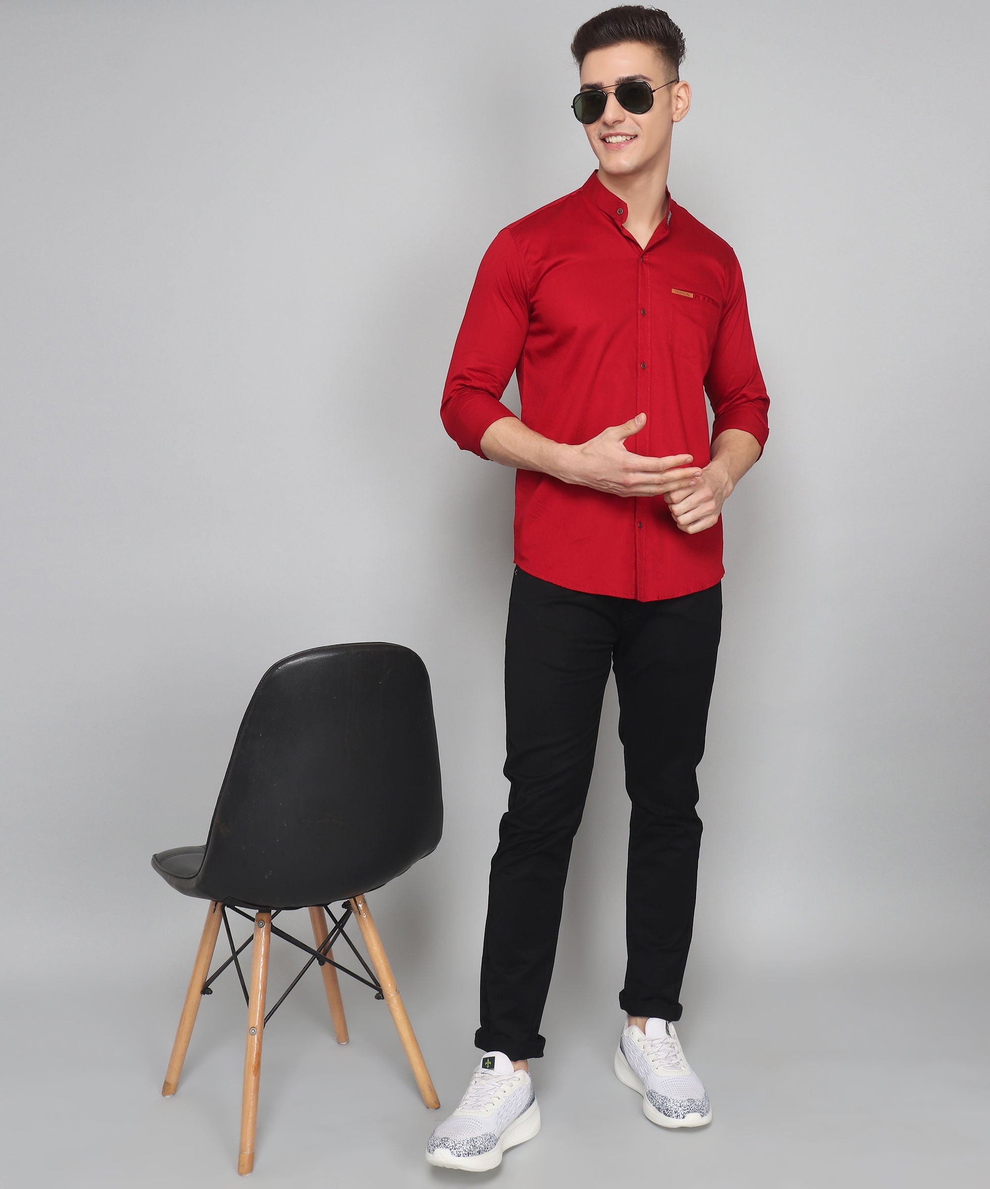 a man in a red shirt standing next to a chair