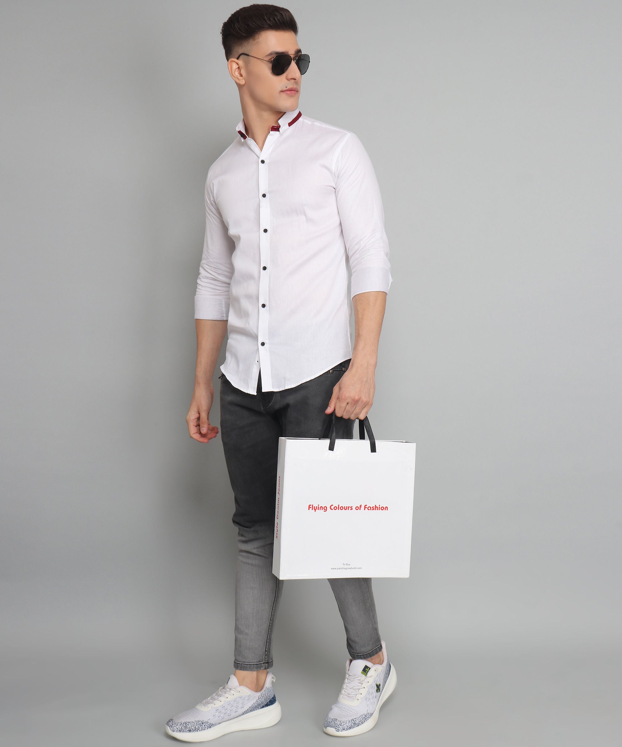 a man holding a shopping bag and wearing sunglasses