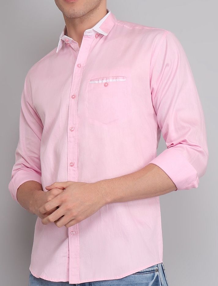 a man wearing a pink shirt and jeans