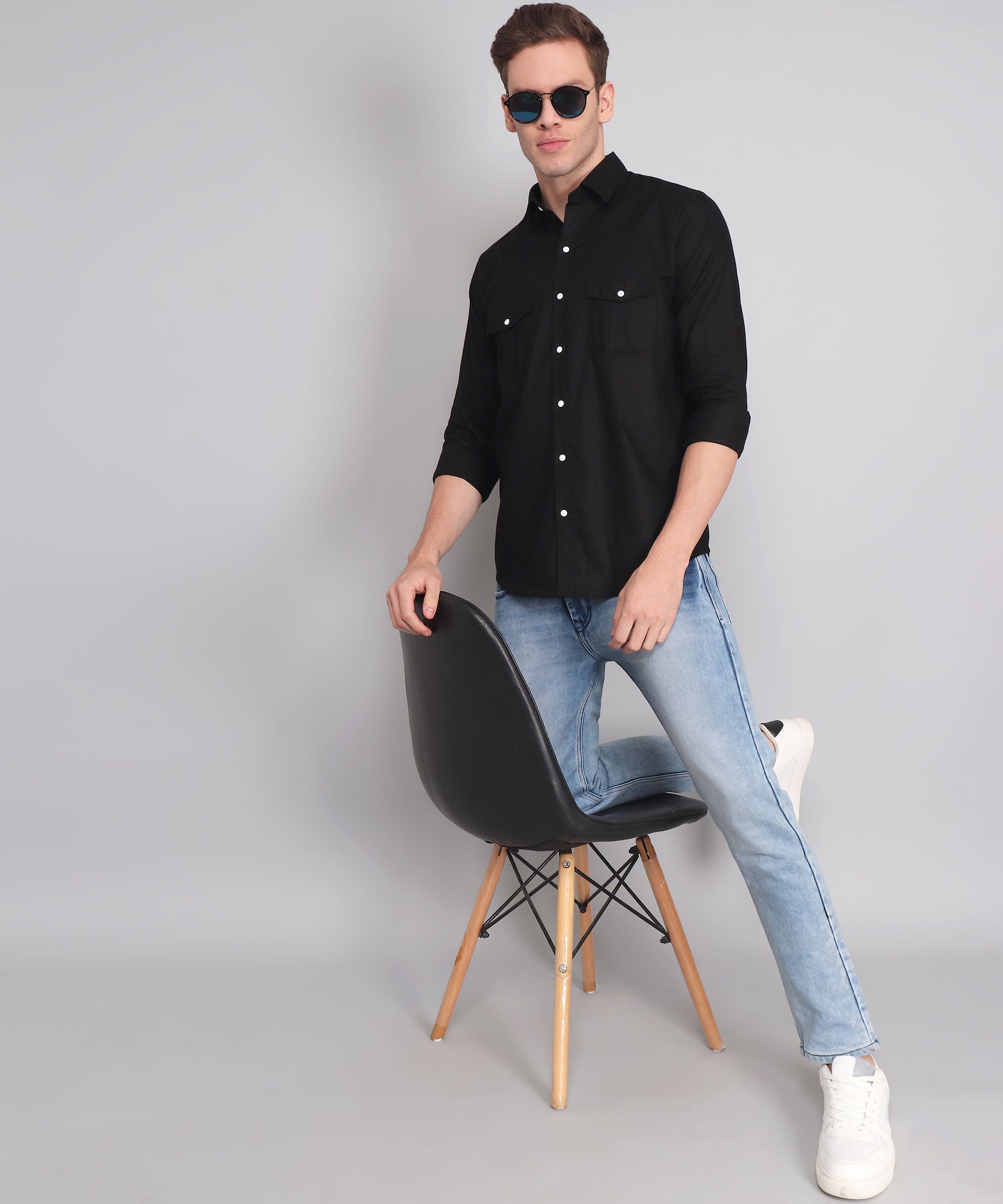 a man sitting on a chair wearing sunglasses