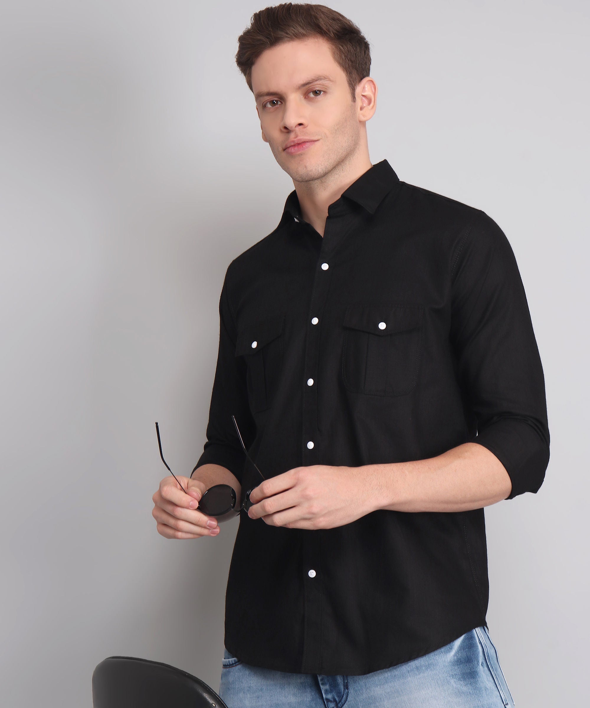 a man in a black shirt holding a pair of scissors