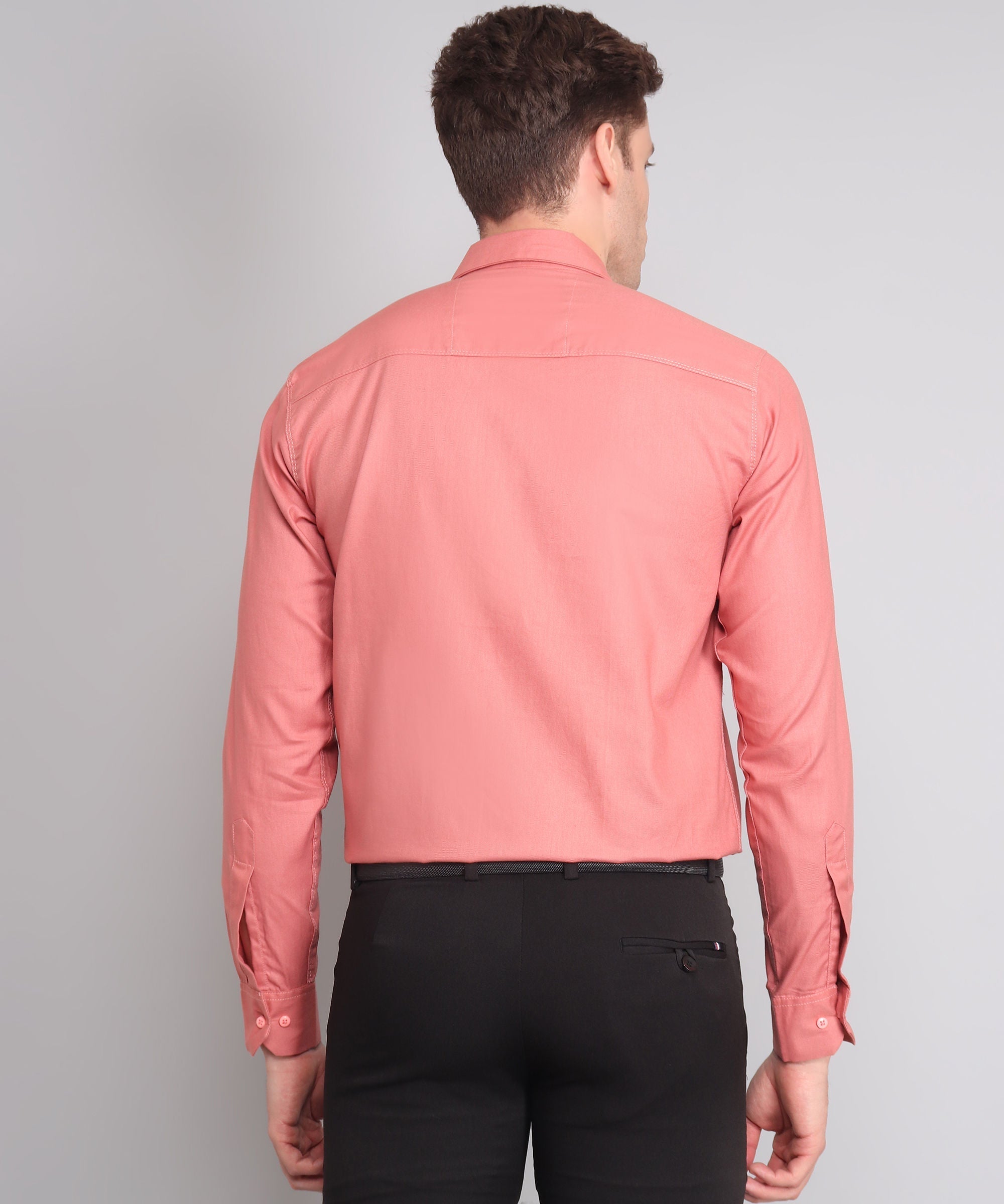 a man wearing a pink shirt and black pants