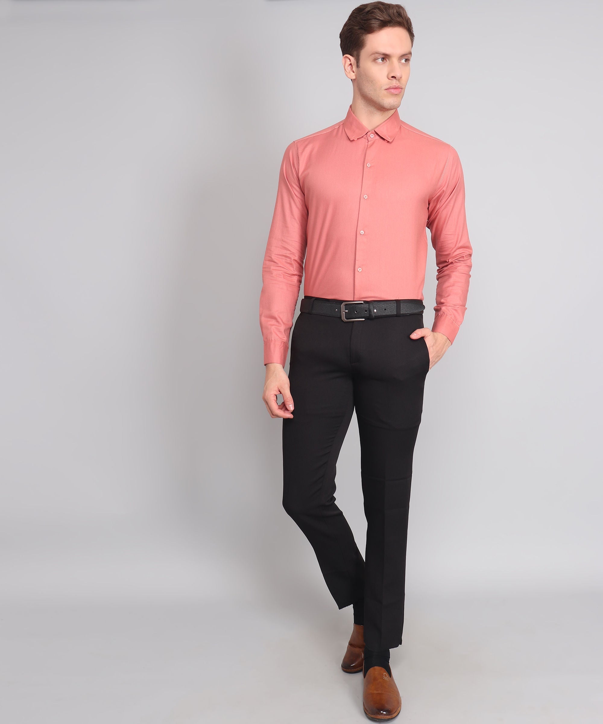 a man in a pink shirt and black pants