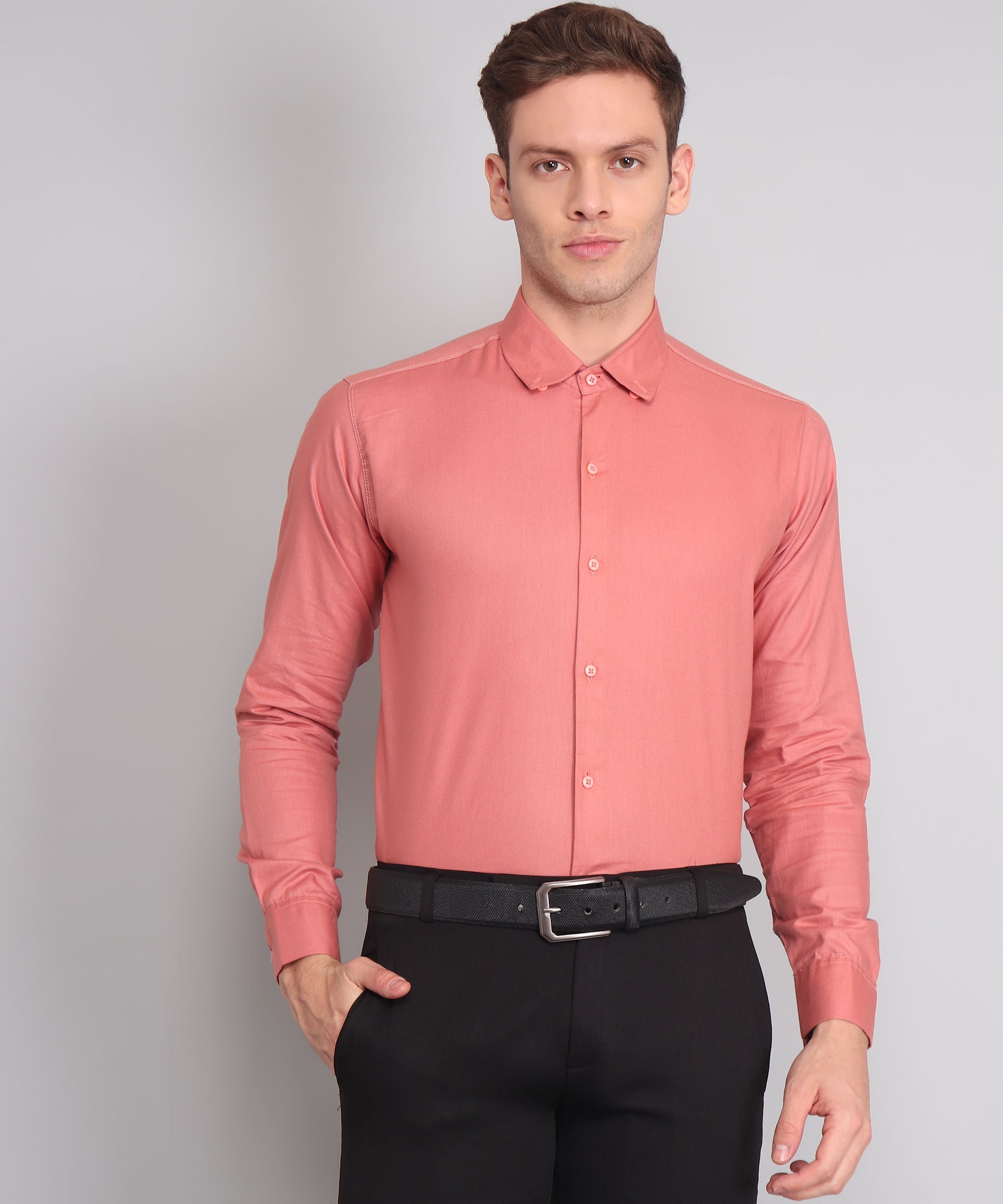 a man wearing a pink shirt and black pants