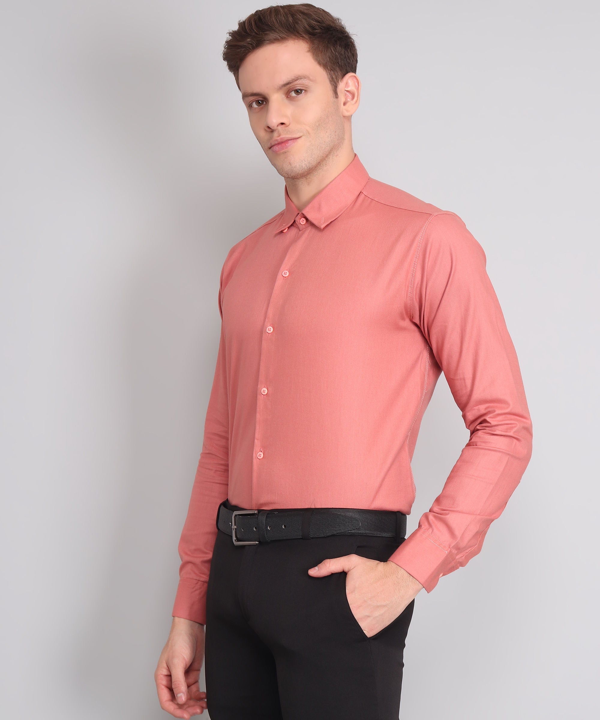 a man wearing a pink shirt and black pants