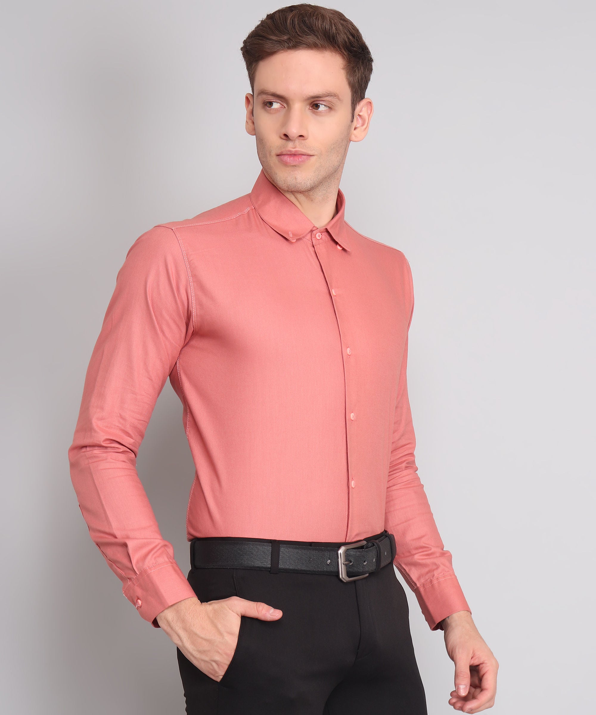 a man wearing a pink shirt and black pants