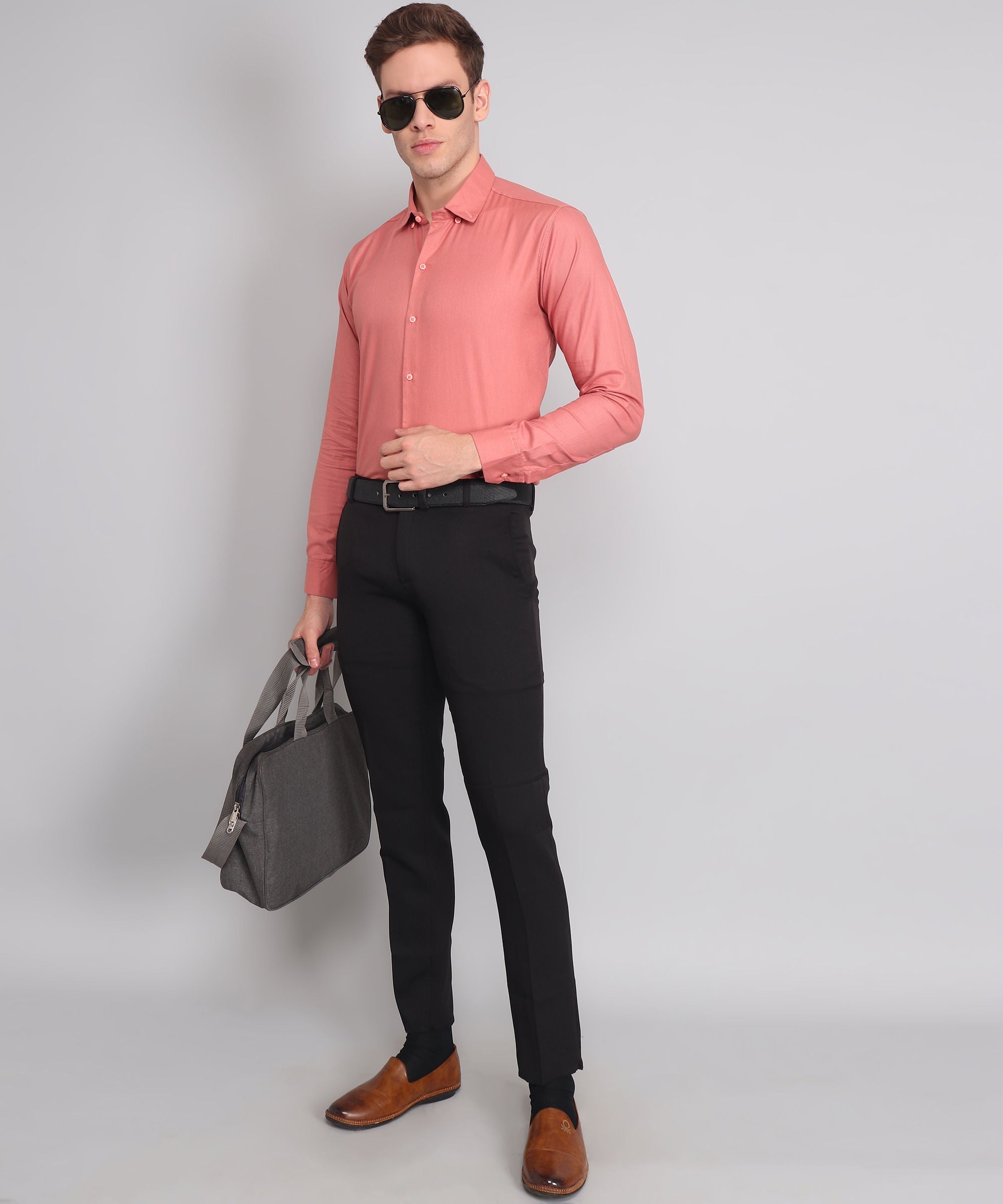 a man in a pink shirt and black pants