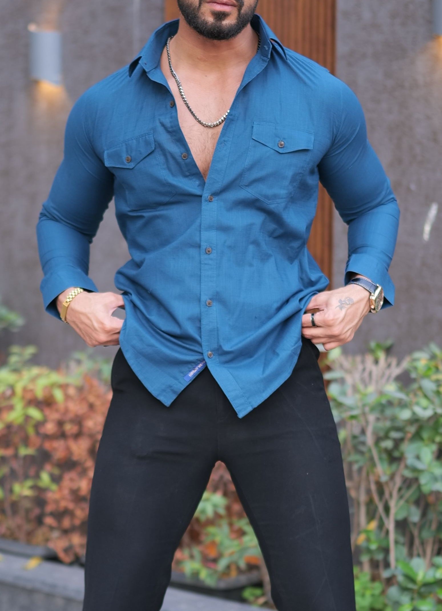 a man wearing a blue shirt and black pants