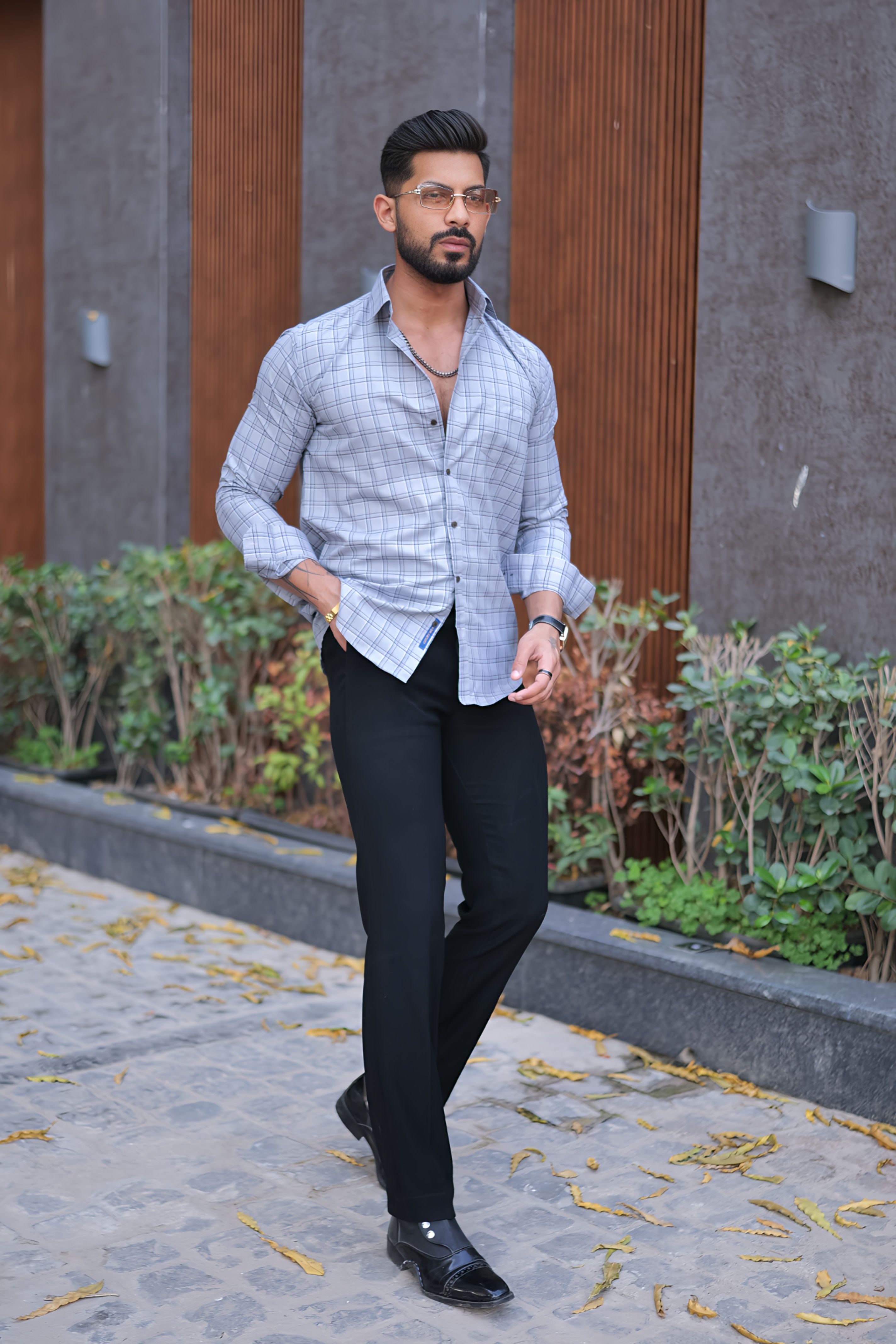 a man standing on a sidewalk wearing a shirt and pants