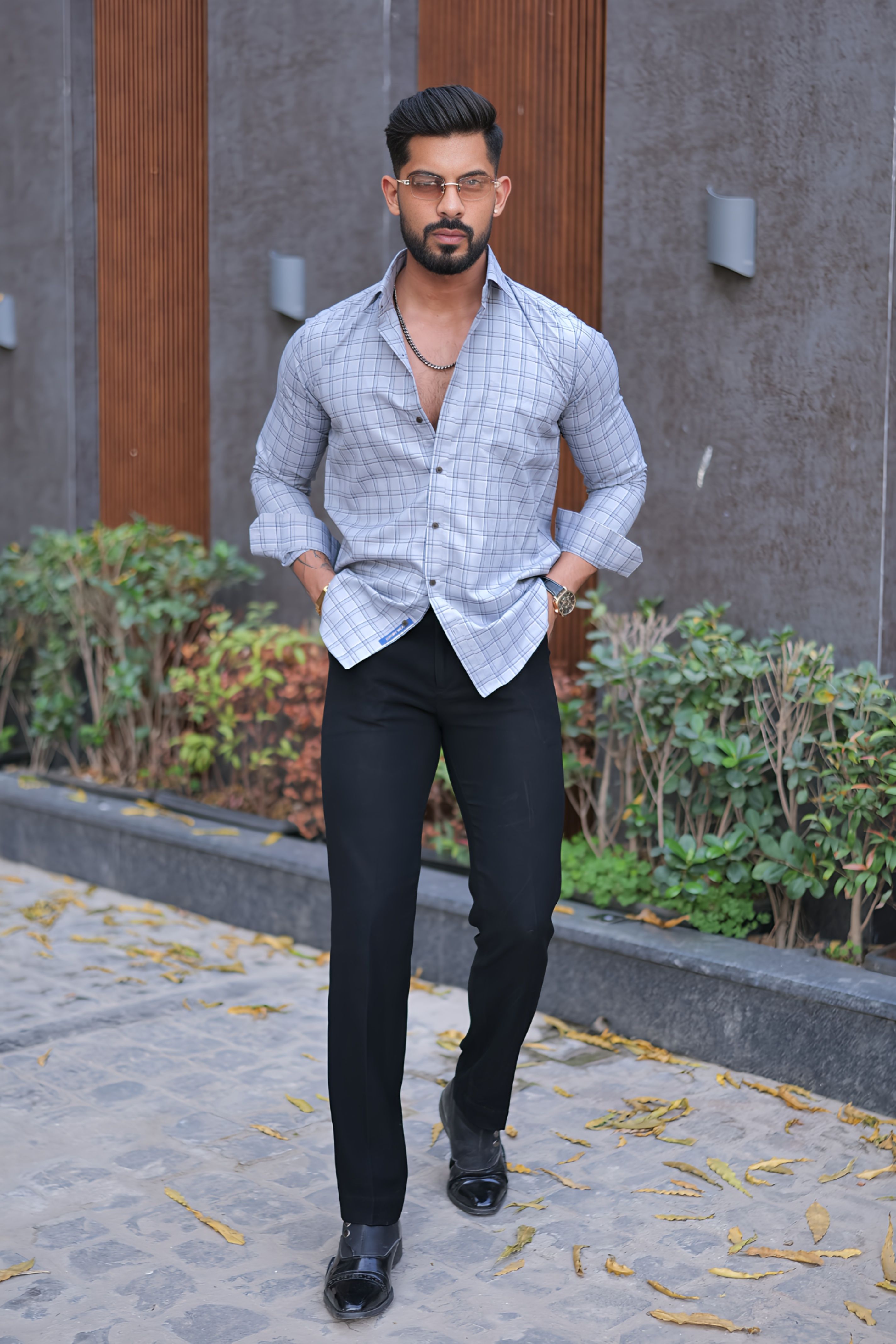 a man standing on a sidewalk wearing a shirt and pants