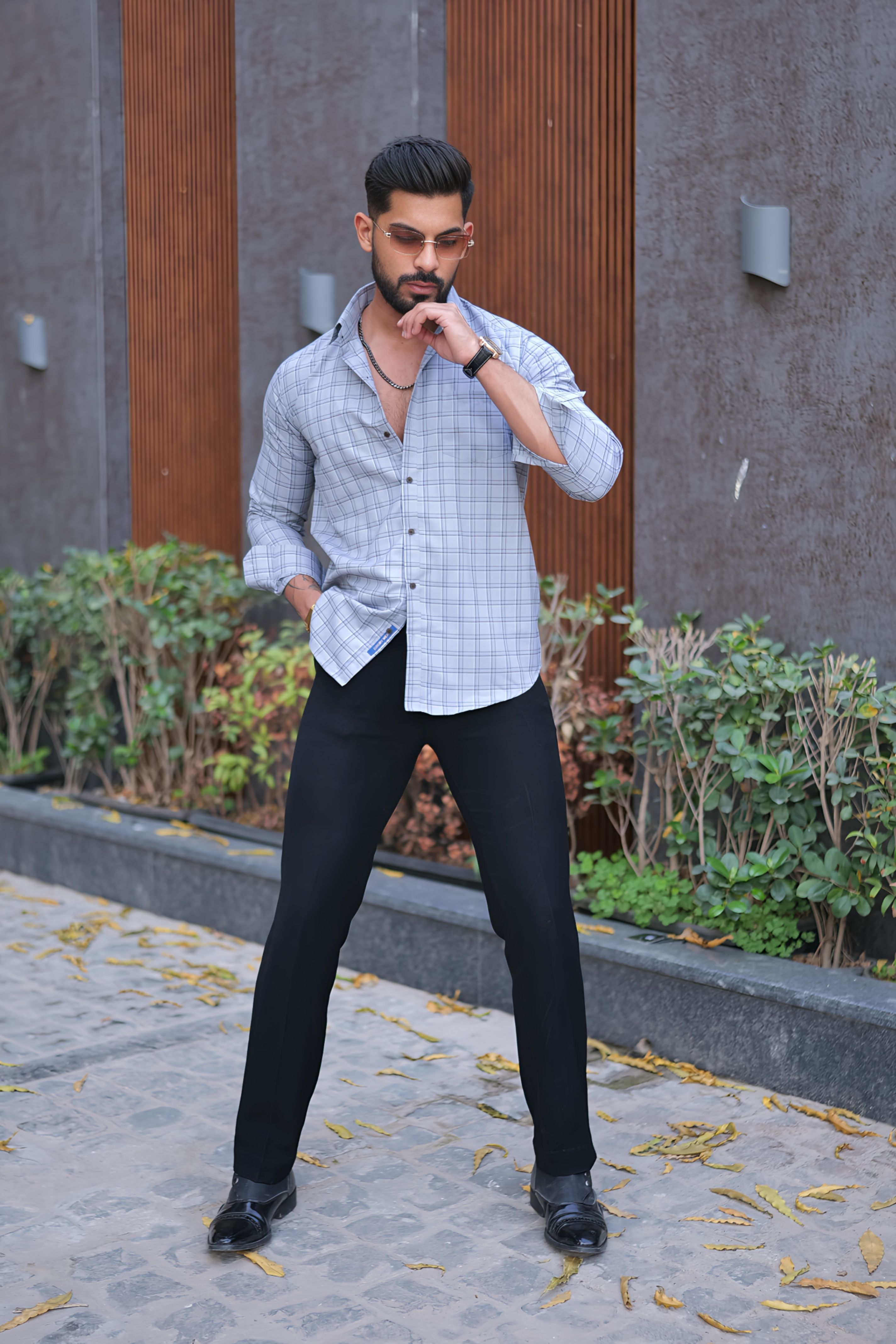 a man standing on a sidewalk with his hands in his pockets