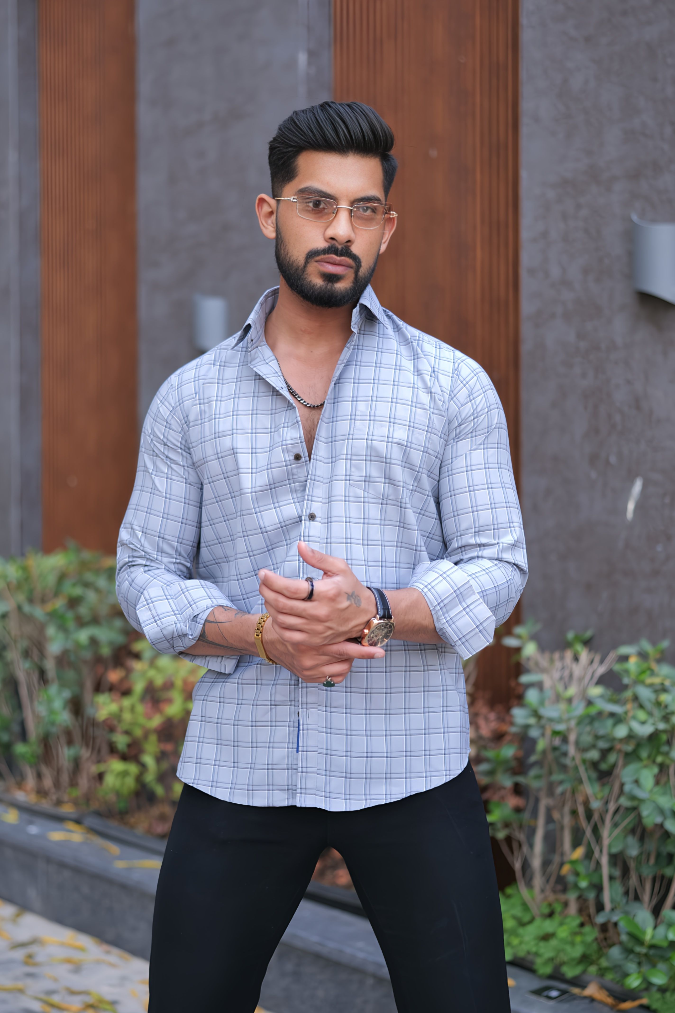 a man standing on a sidewalk with his hands together