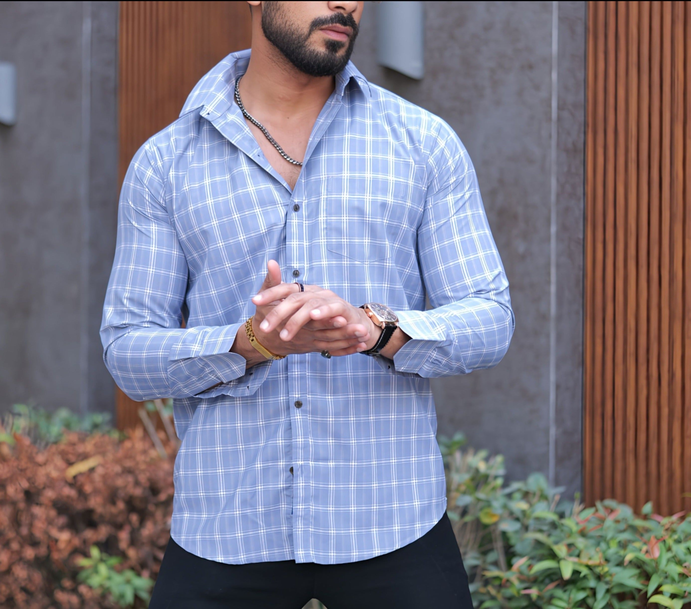 a man standing in front of a building wearing a watch