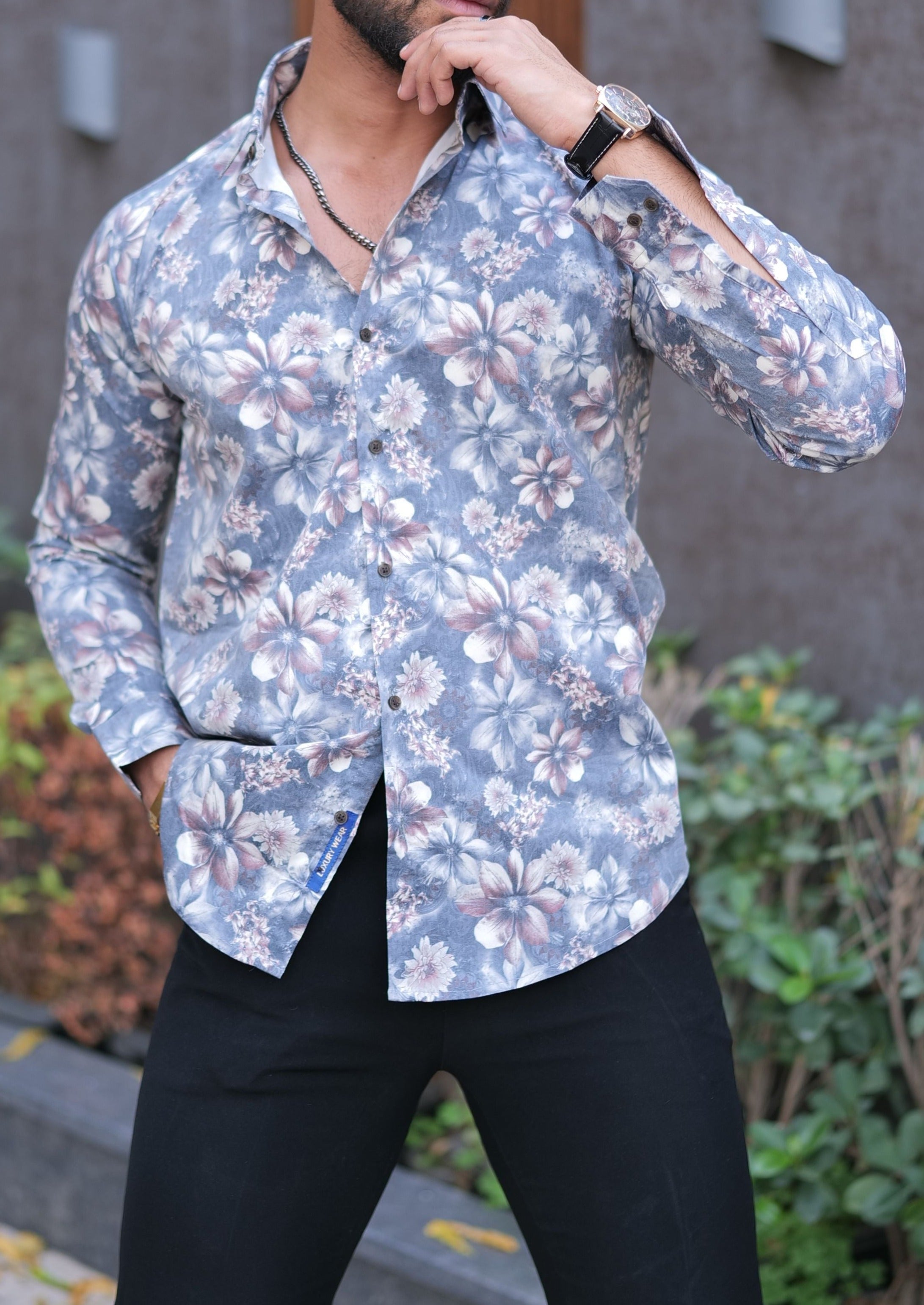 a man in a floral shirt poses for a picture
