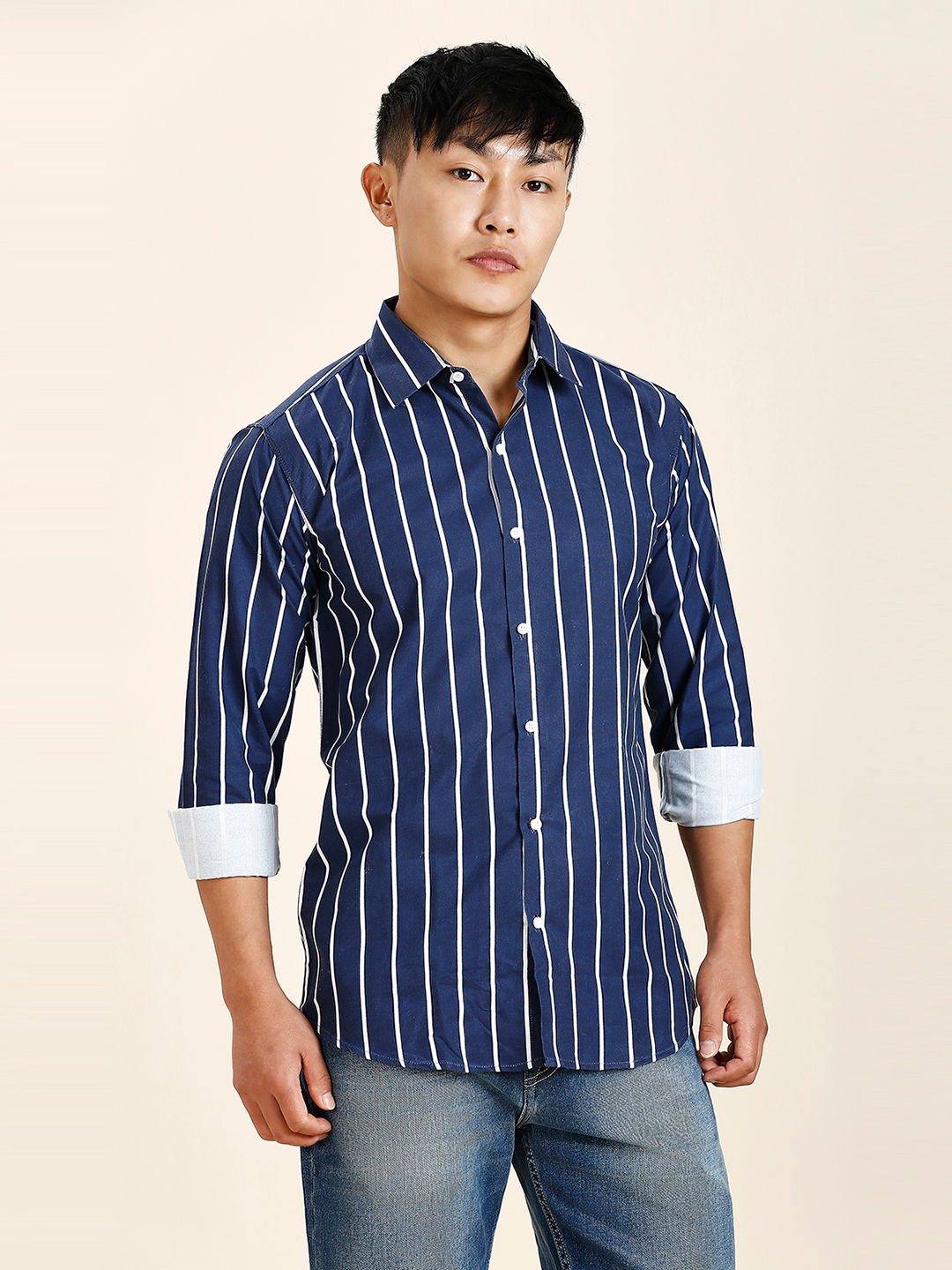 a man in a blue striped shirt is posing for a picture