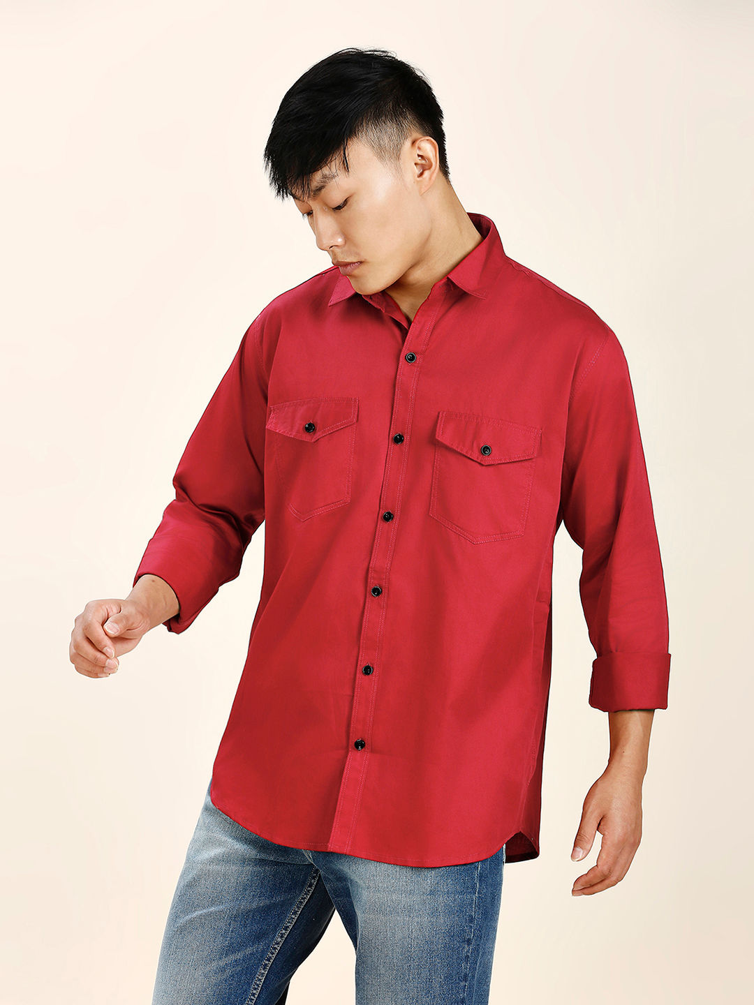 a man wearing a red shirt and jeans