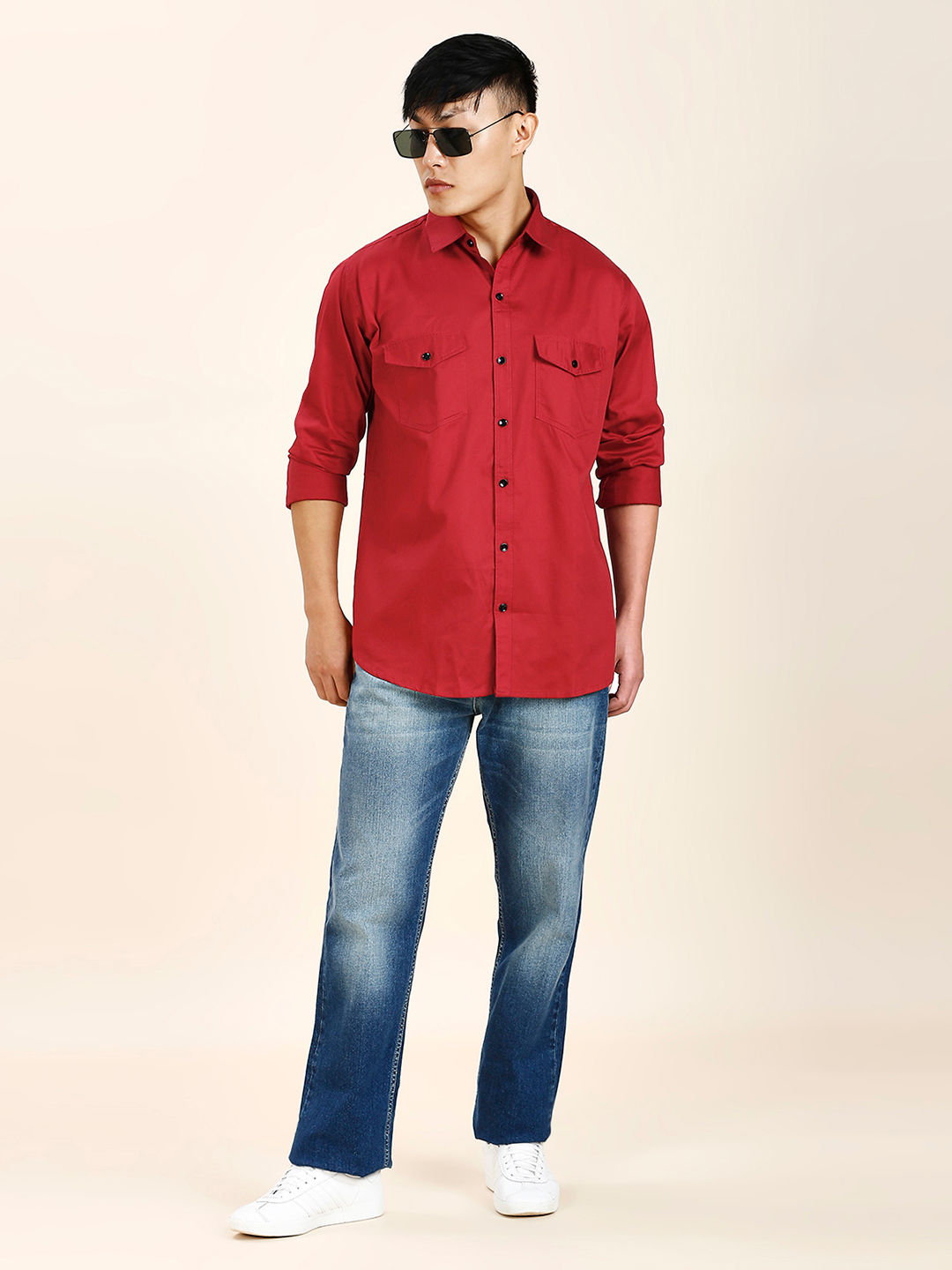 a man wearing a red shirt and jeans