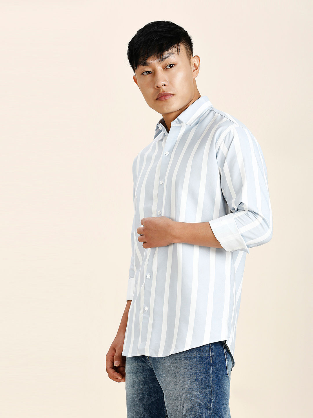 a man in a striped shirt poses for a picture