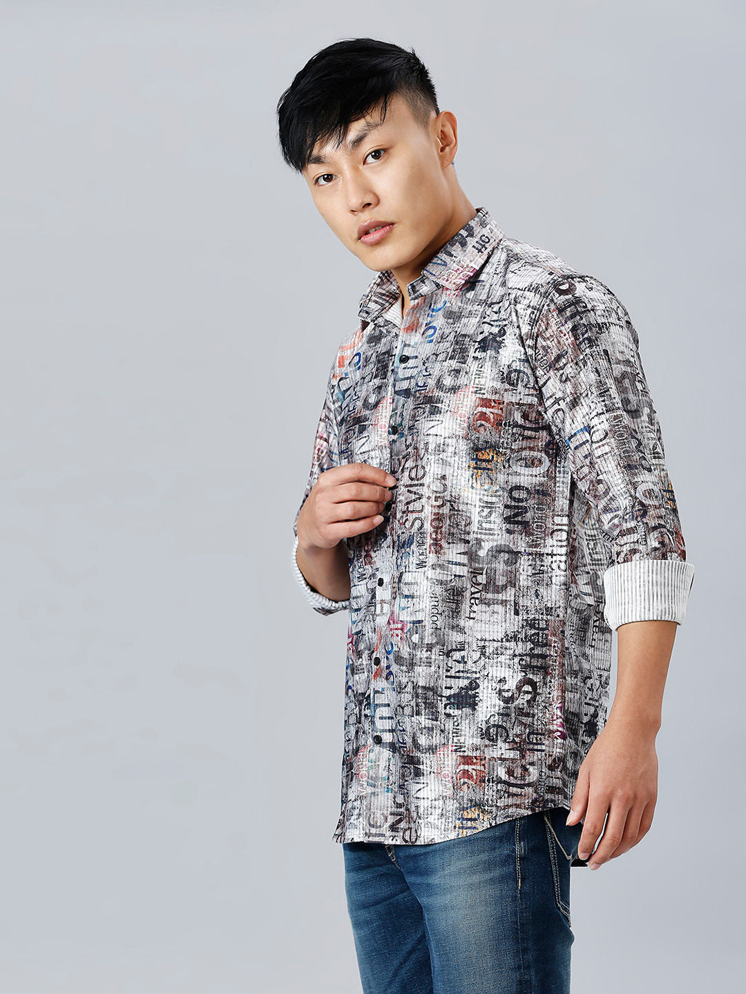 a man in a patterned shirt poses for a picture