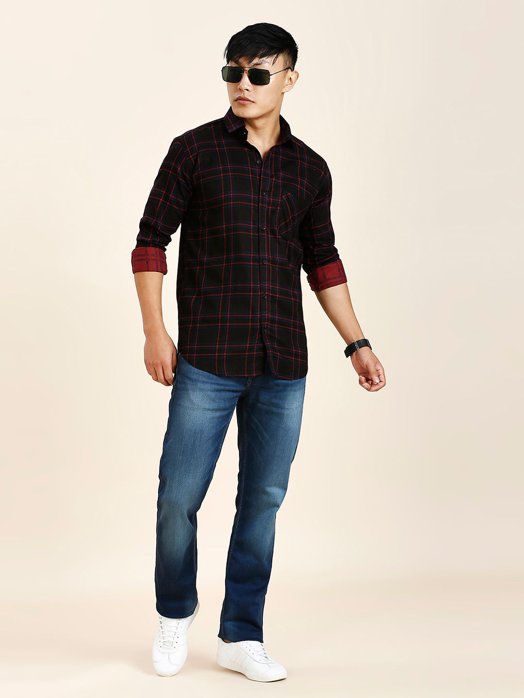 a man in a black and red shirt and jeans