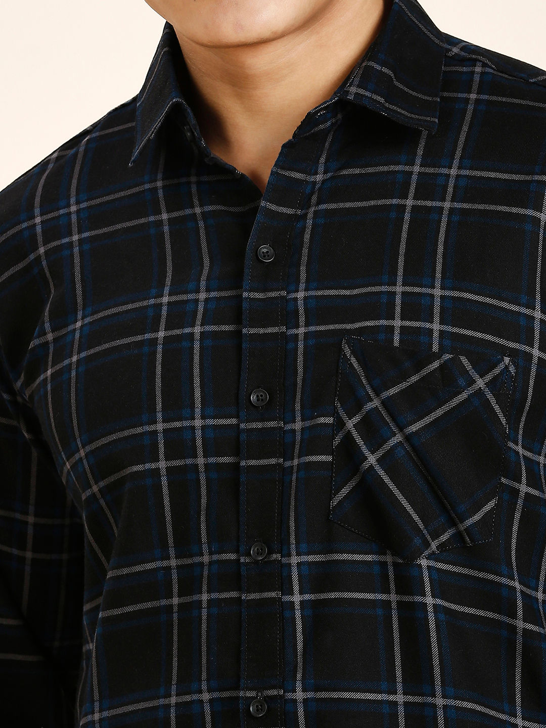 a man wearing a black and blue plaid shirt