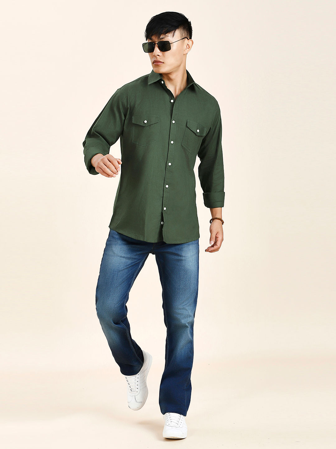 a man wearing a green shirt and jeans