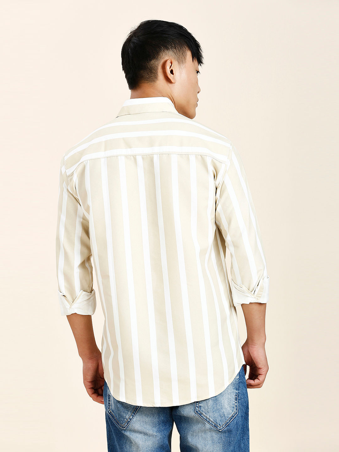 a man in a striped shirt is looking away from the camera