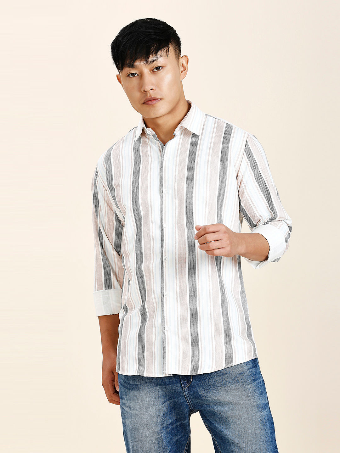 a man in a striped shirt poses for a picture