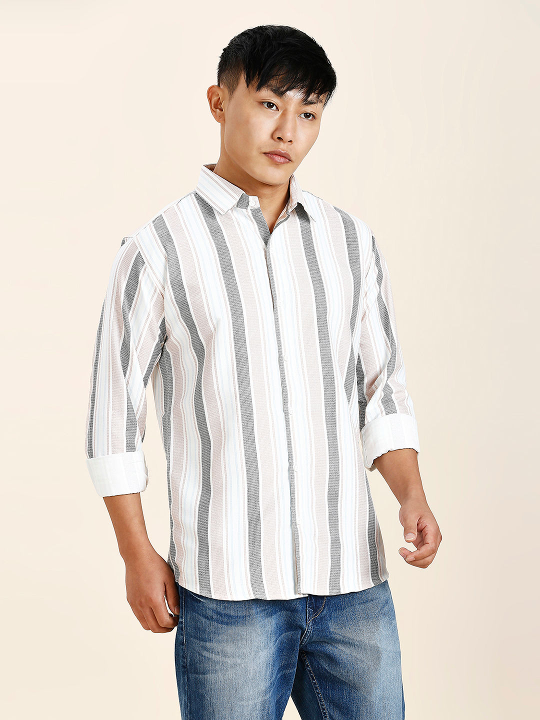 a man in a striped shirt poses for a picture