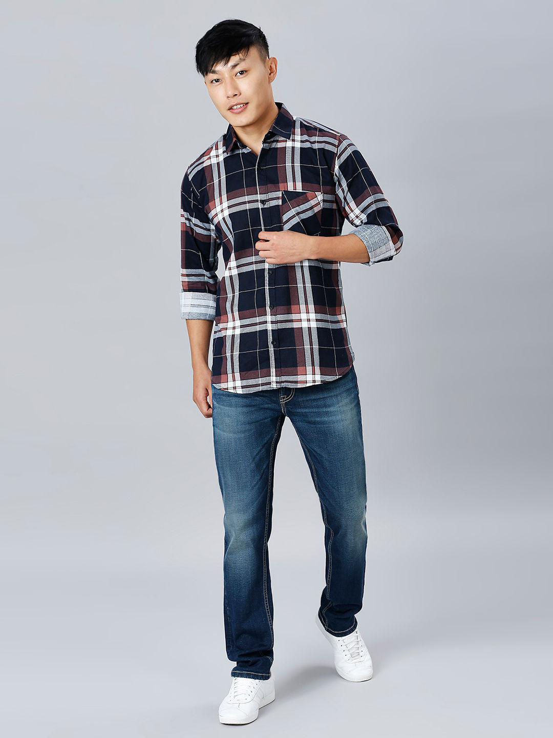 a man in a plaid shirt poses for a picture