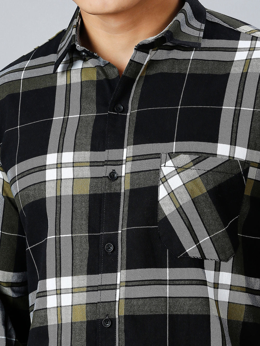 a man wearing a black and grey plaid shirt