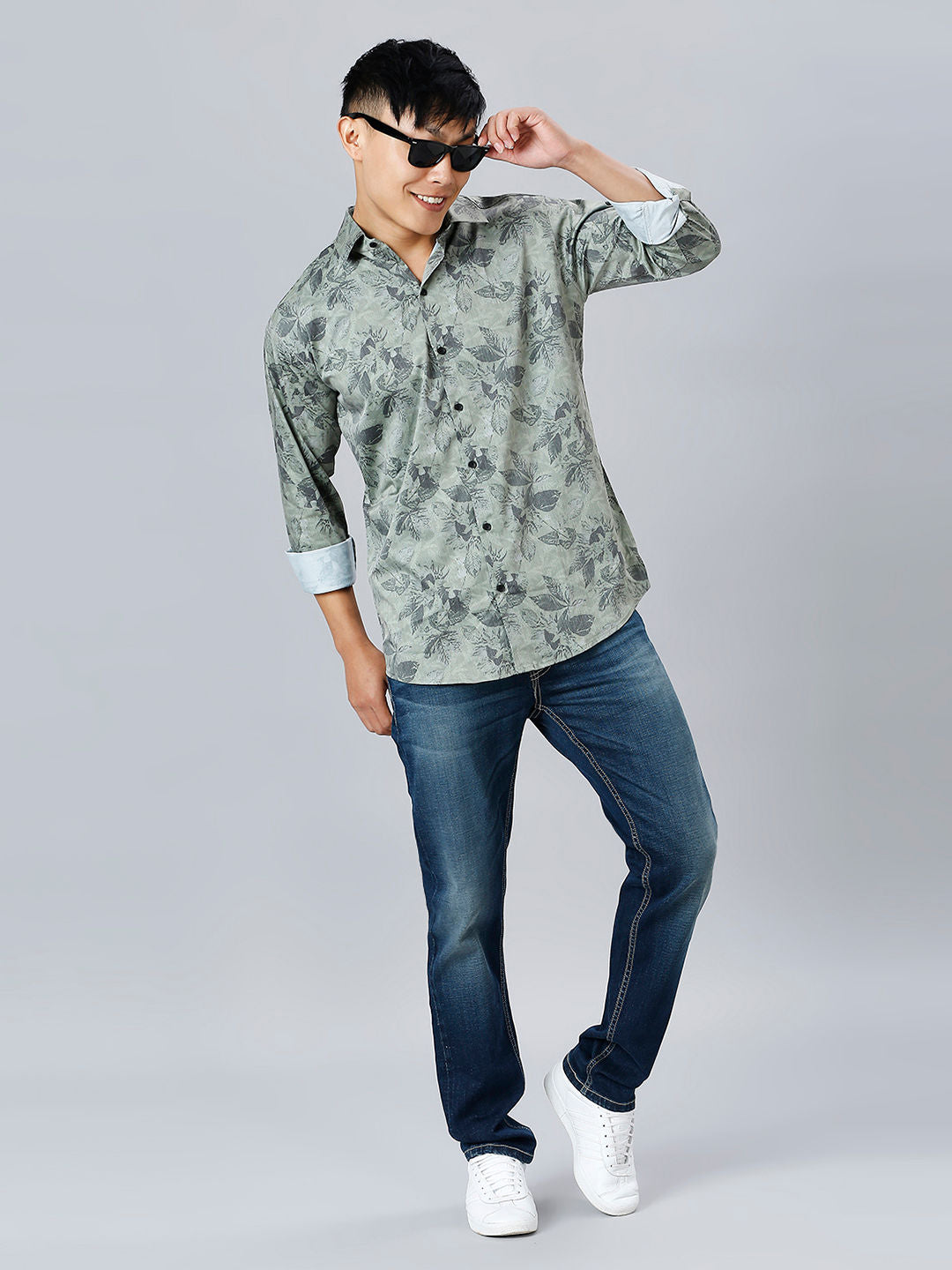 a man in a shirt and jeans poses for a picture