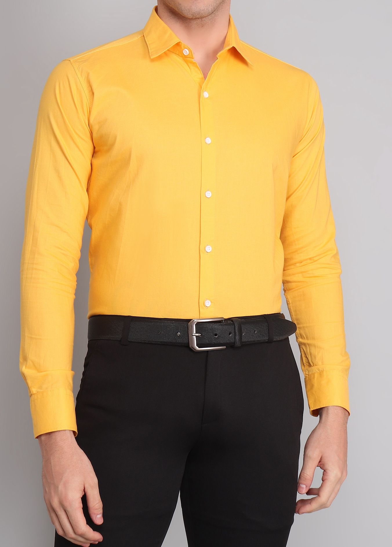 a man wearing a yellow shirt and black pants