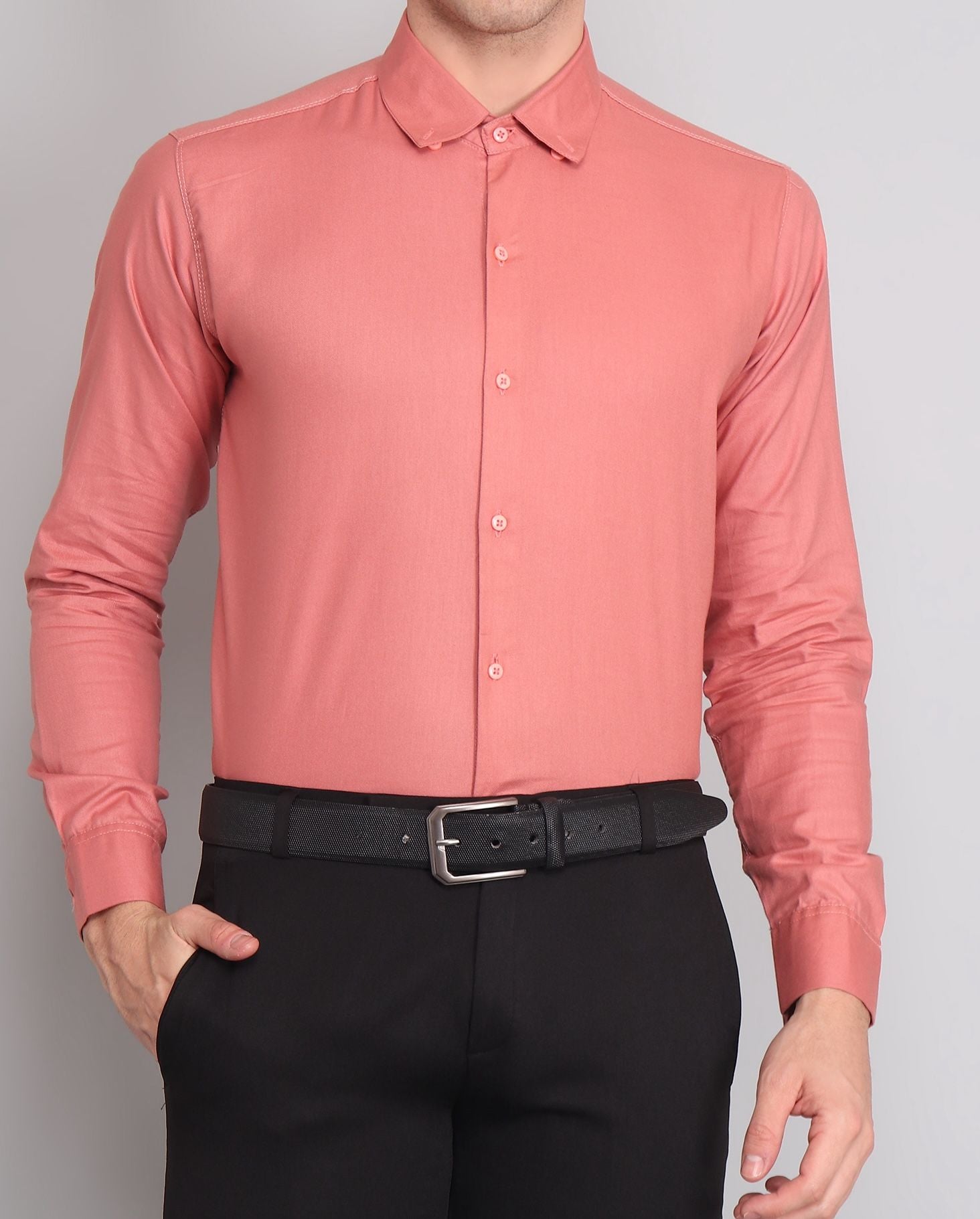 a man wearing a pink shirt and black pants