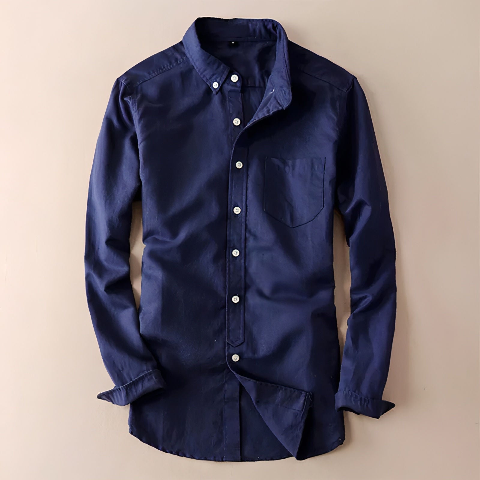 a blue shirt hanging up against a wall