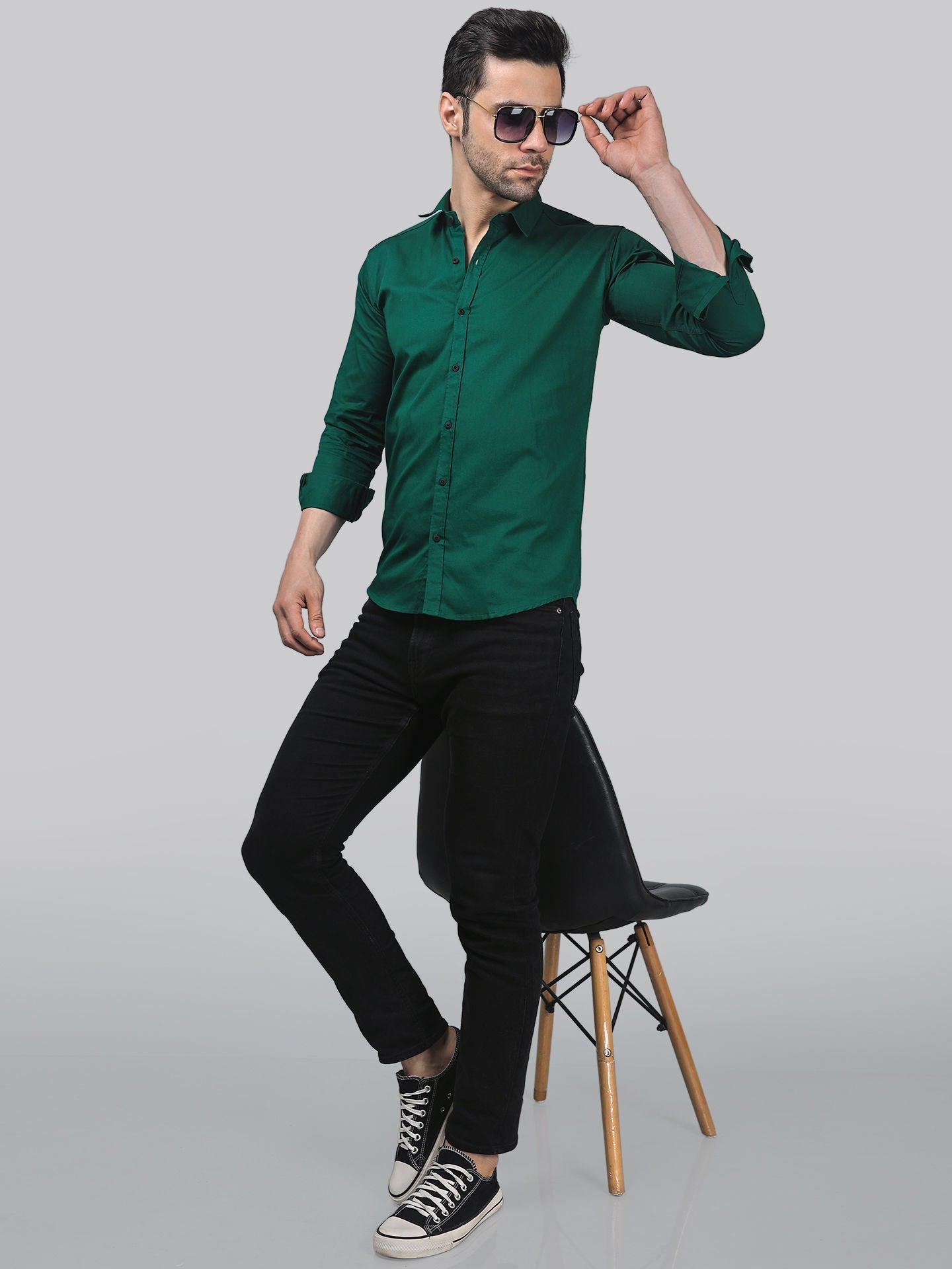 a man in a green shirt is sitting on a chair