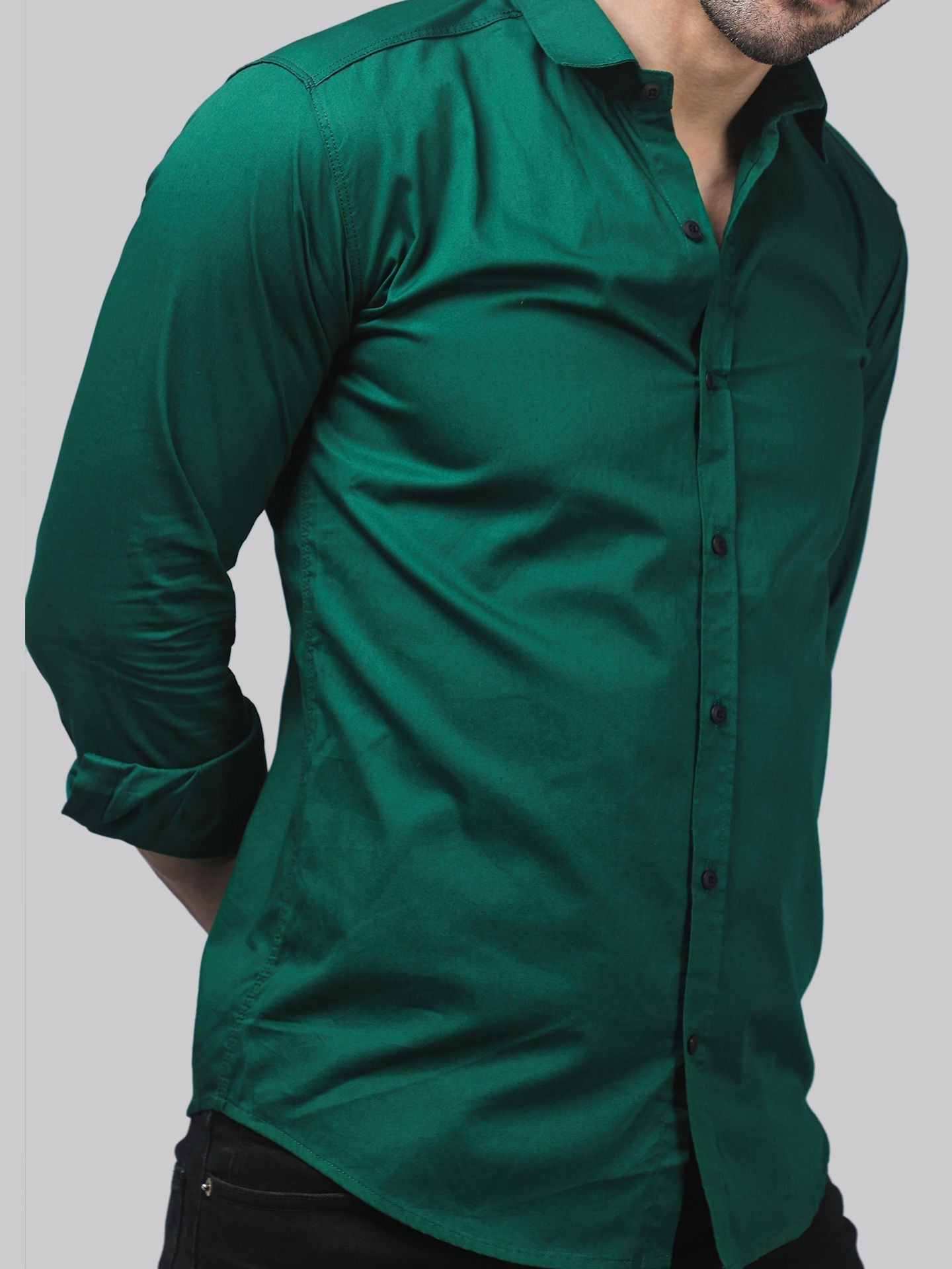 a man wearing a green shirt and black pants