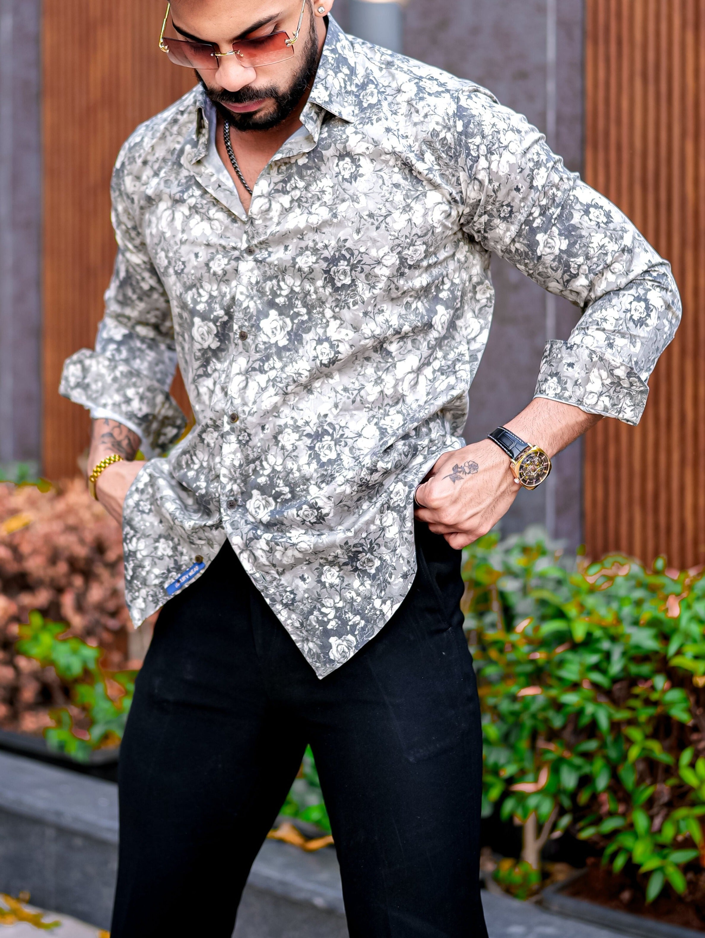 a man with a beard wearing a shirt and black pants