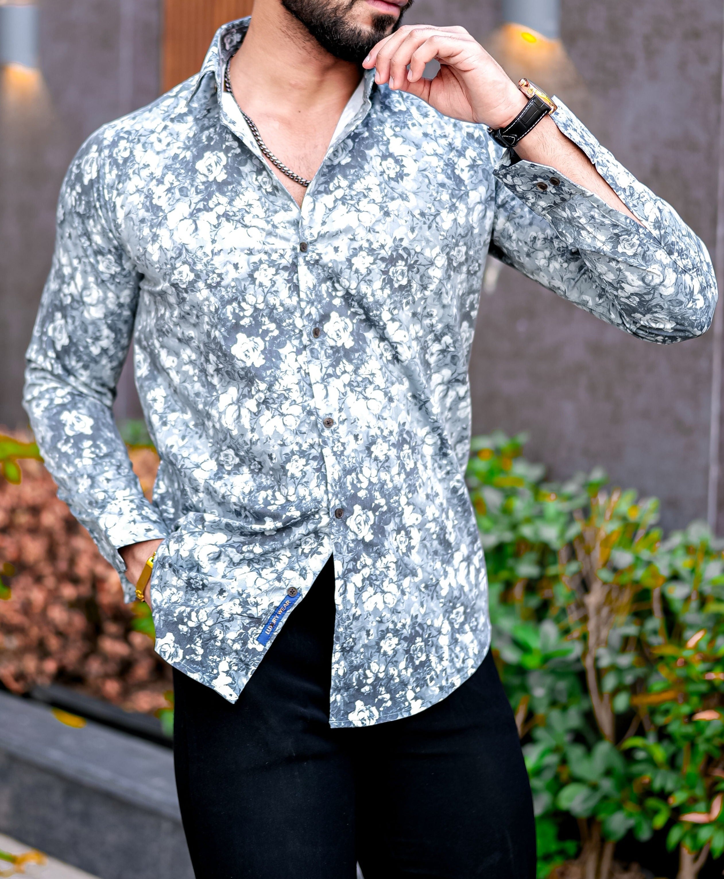 a man in a floral shirt poses for a picture