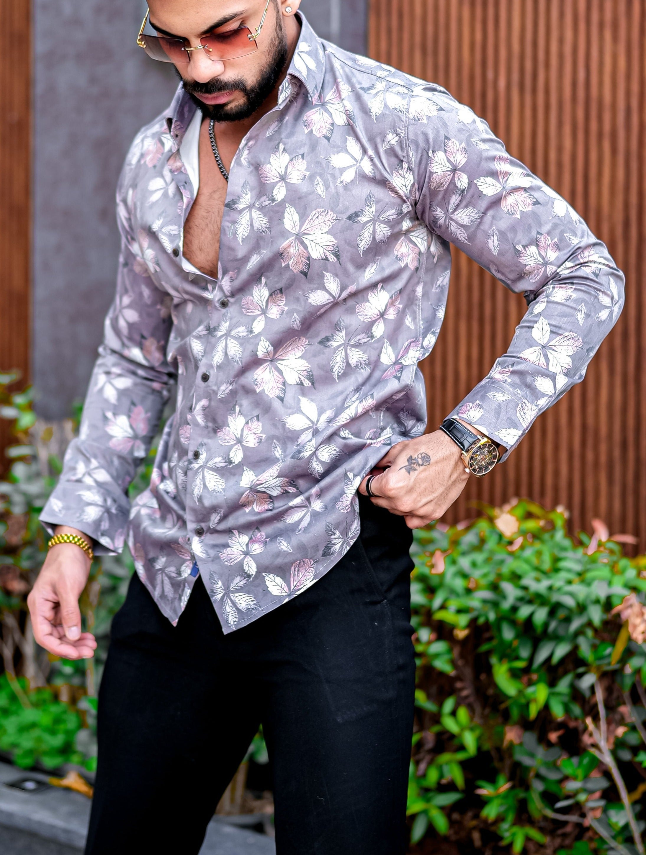 a man with a beard wearing a shirt and black pants