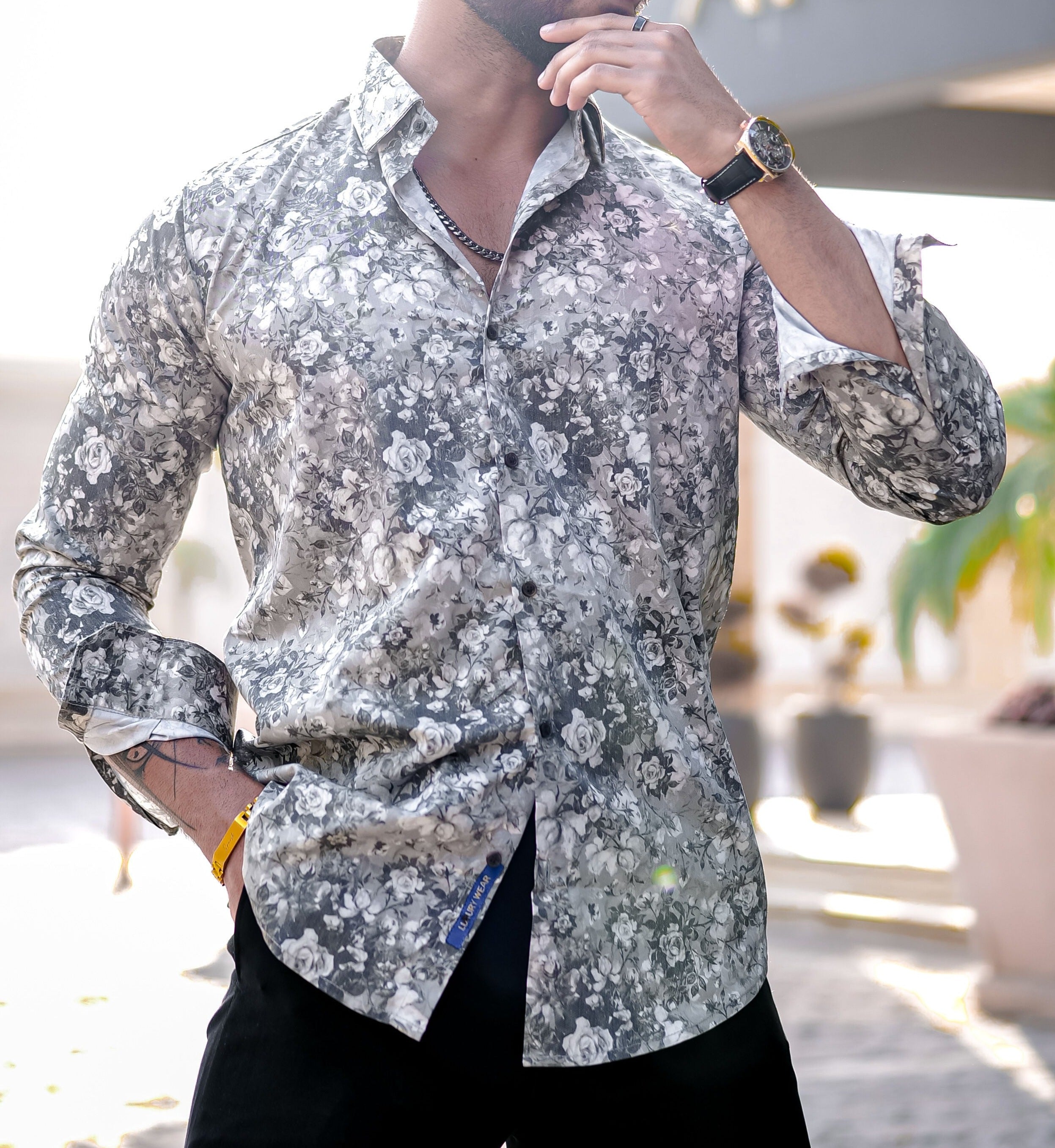 a man in a floral shirt brushing his teeth