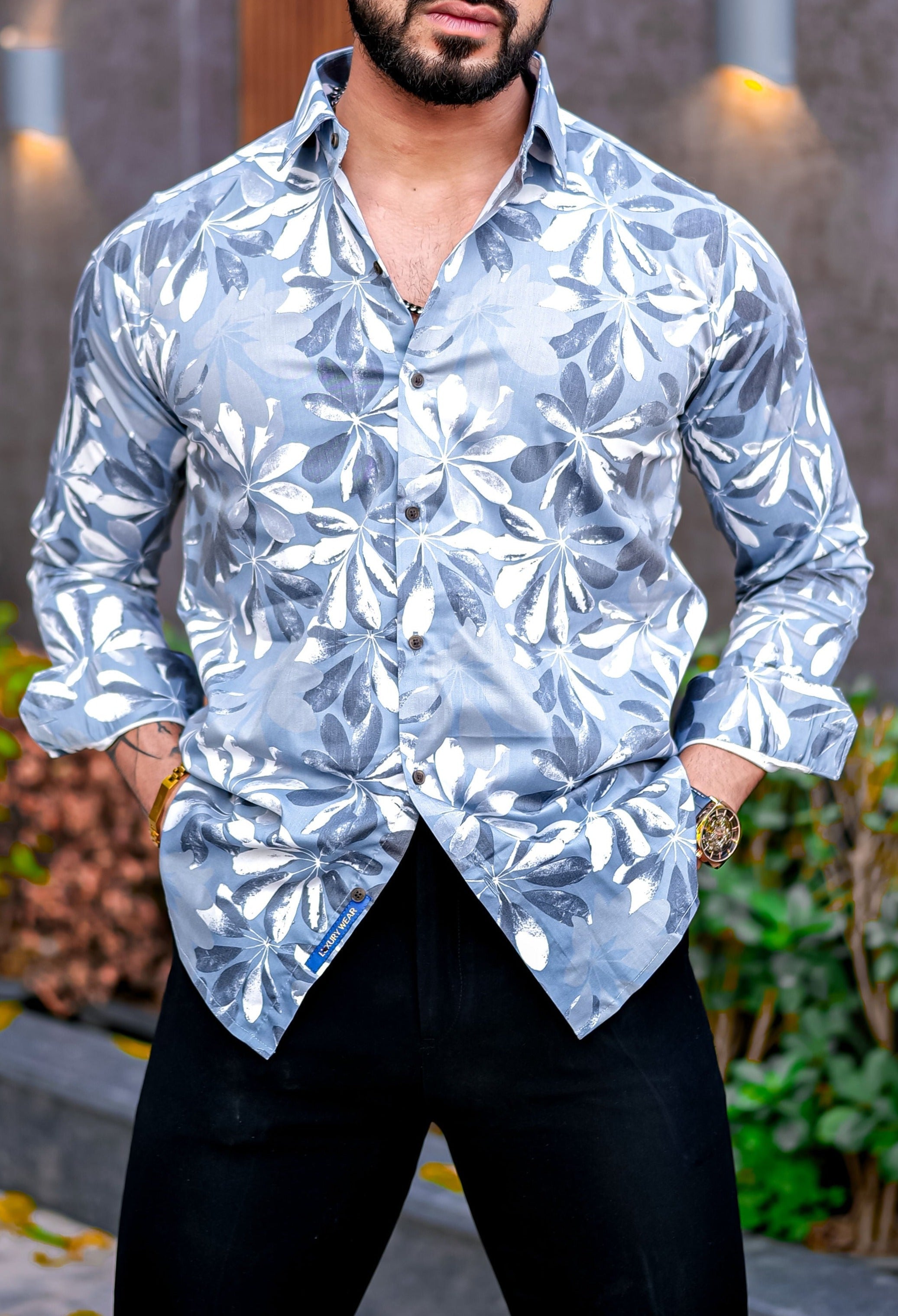 a man wearing a silver shirt and black pants