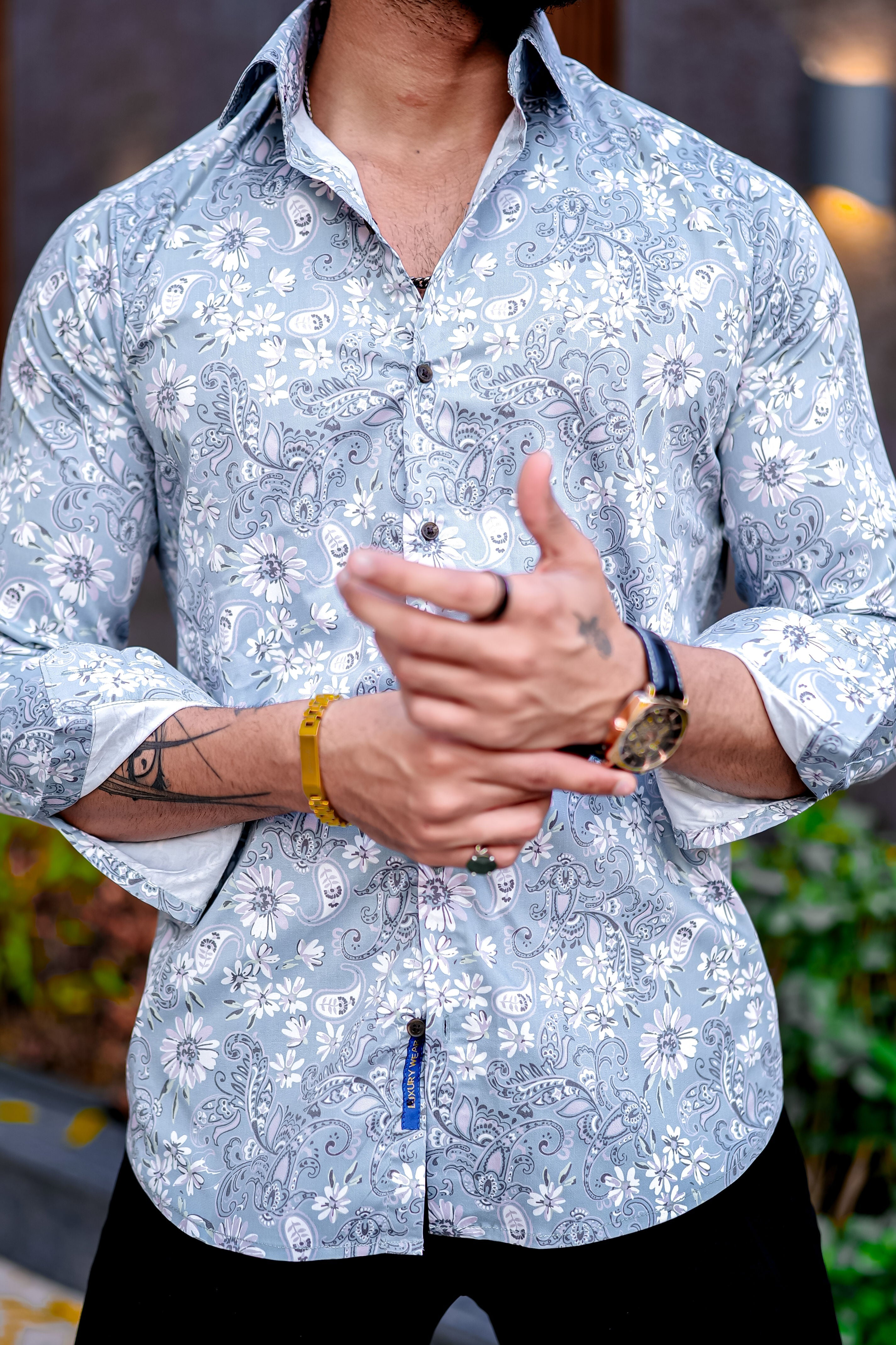 a man in a blue shirt is holding his hands together