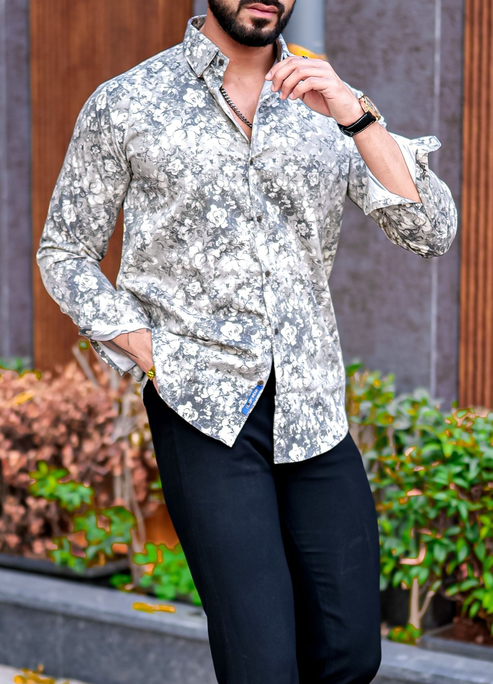 a man in a floral shirt poses for a picture