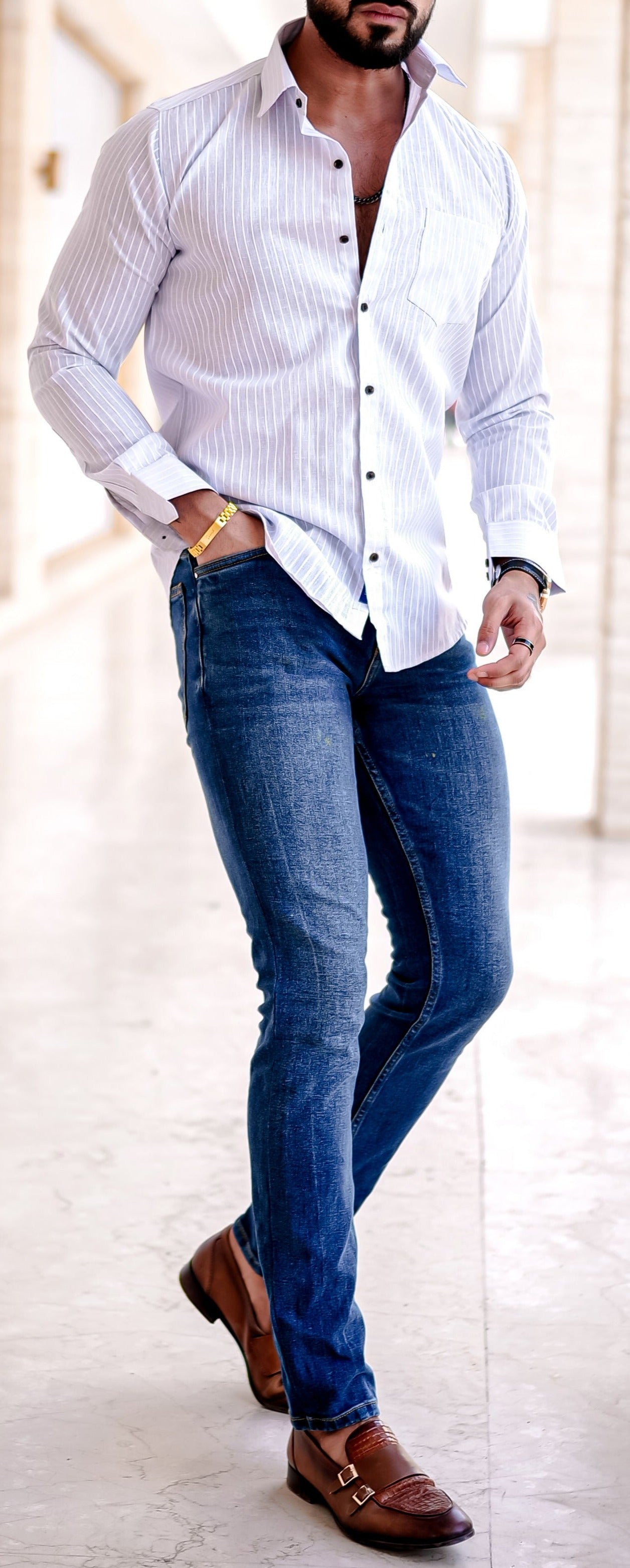a man in a white shirt and jeans posing for a picture