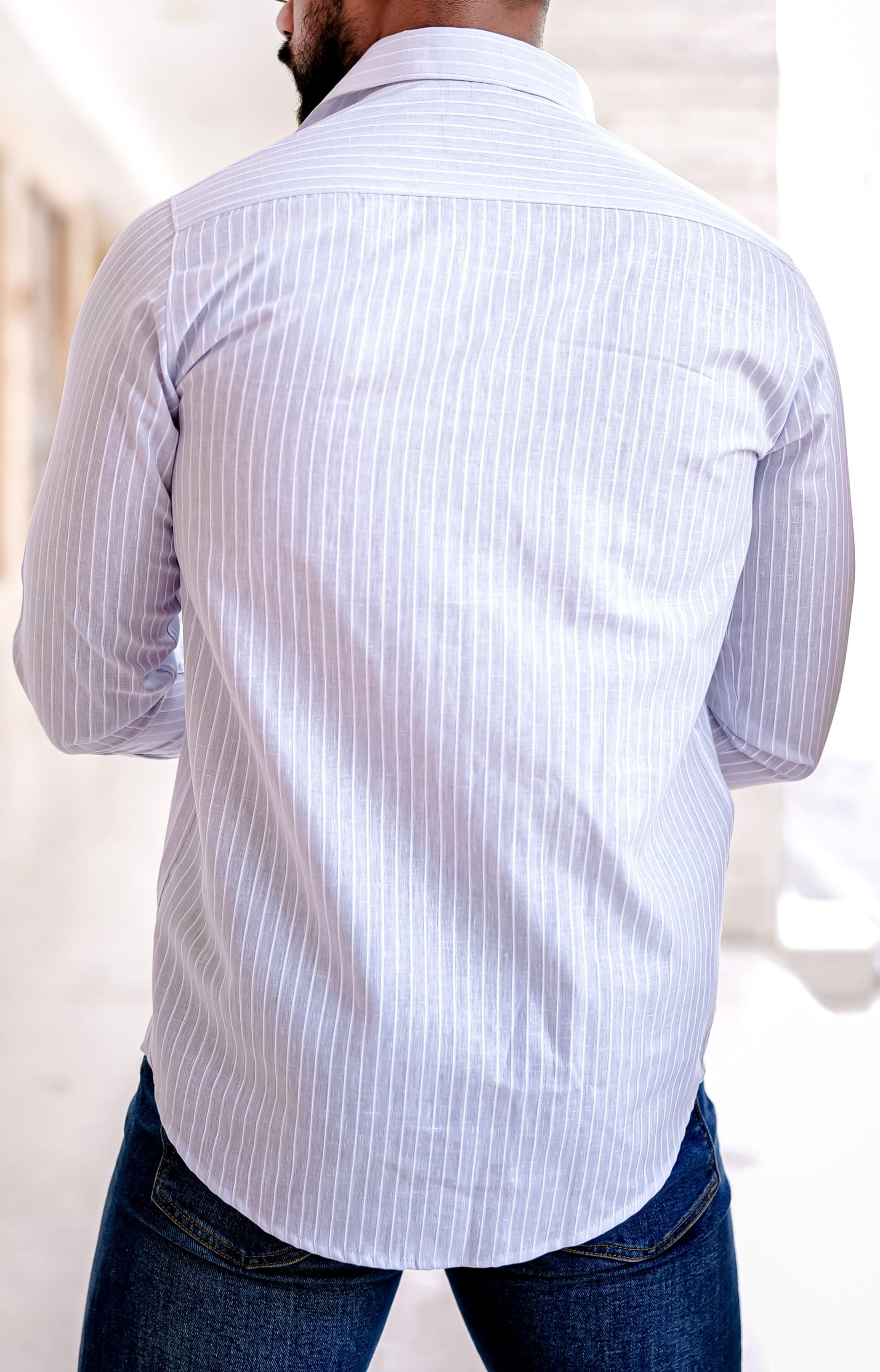 a man in a Check shirt leaning against a wall