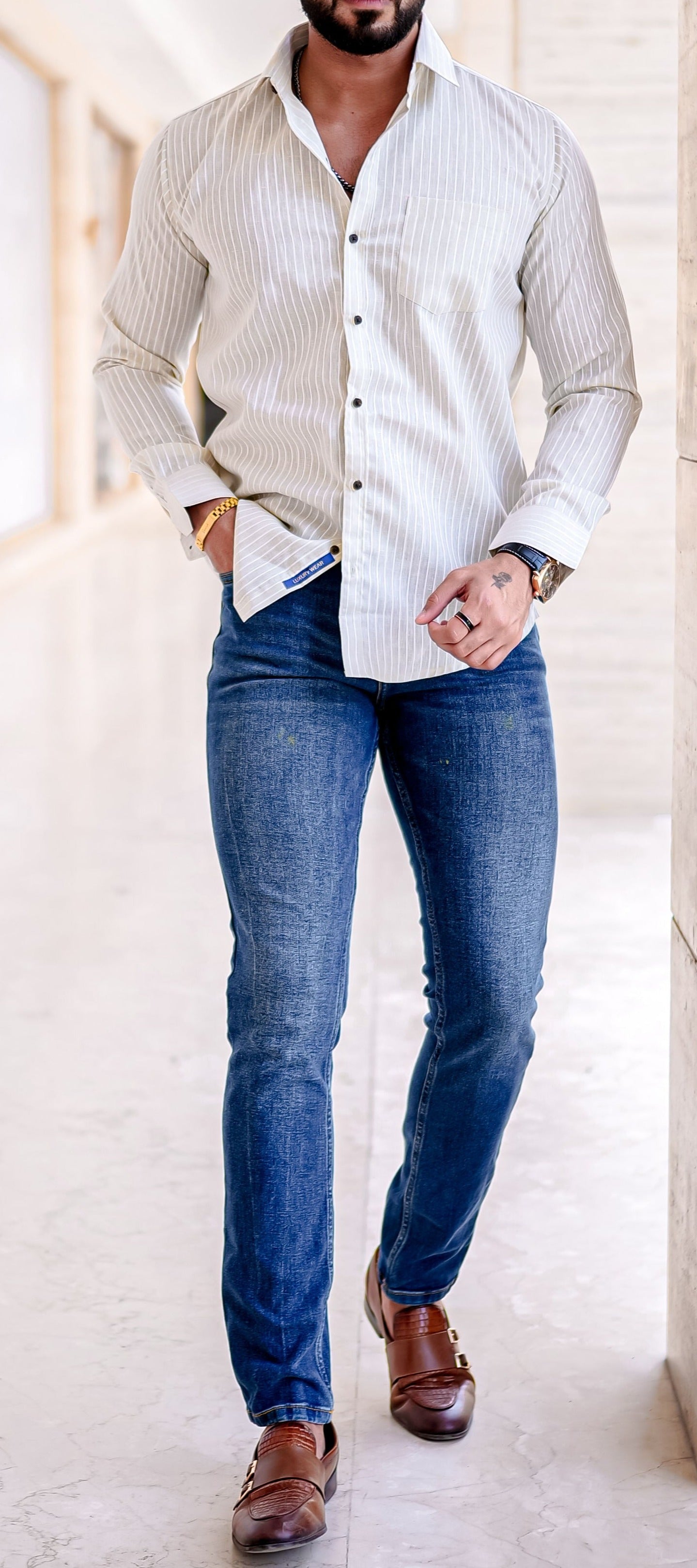 a man in a white shirt and jeans posing for a picture