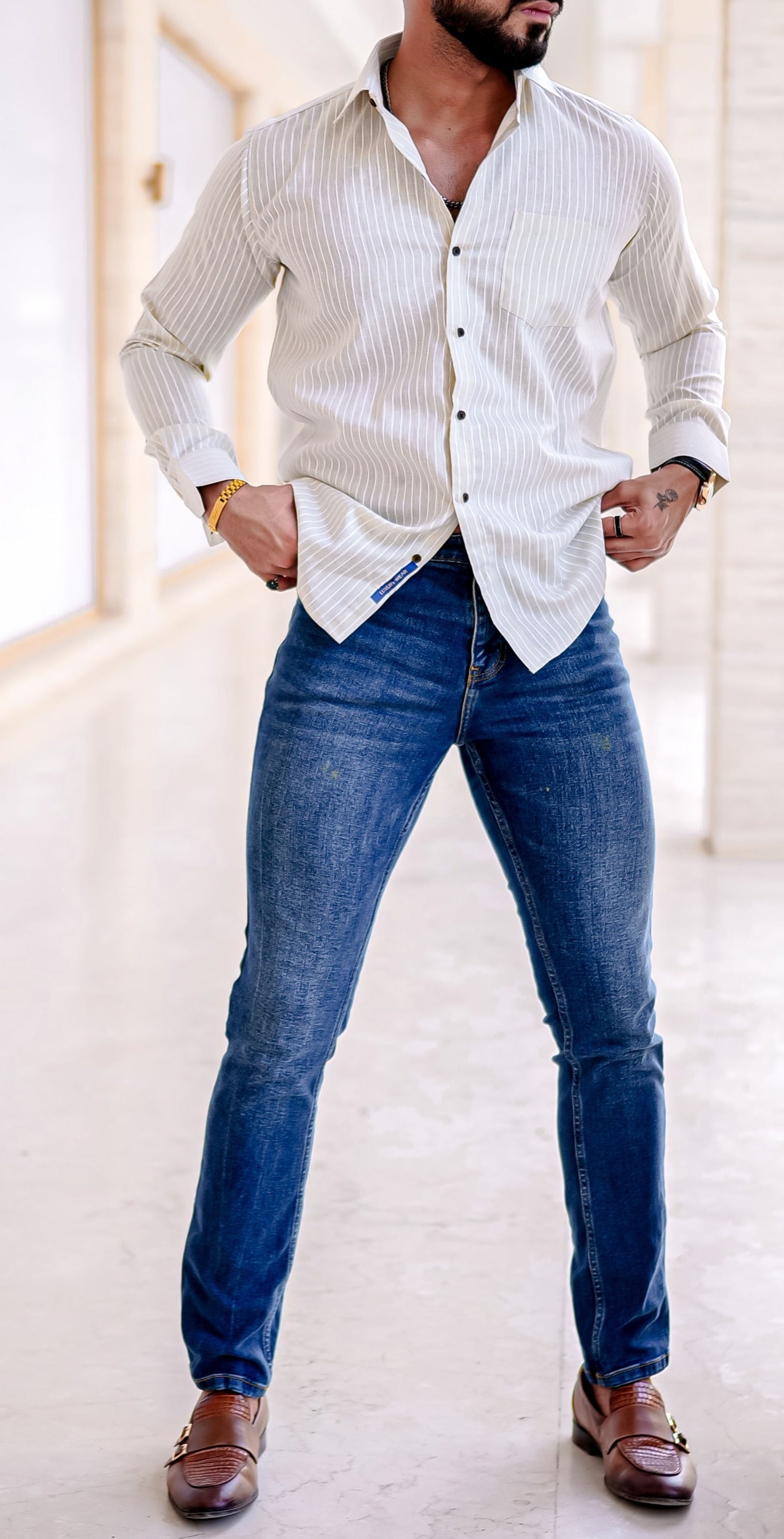 a man in a white shirt and jeans posing for a picture