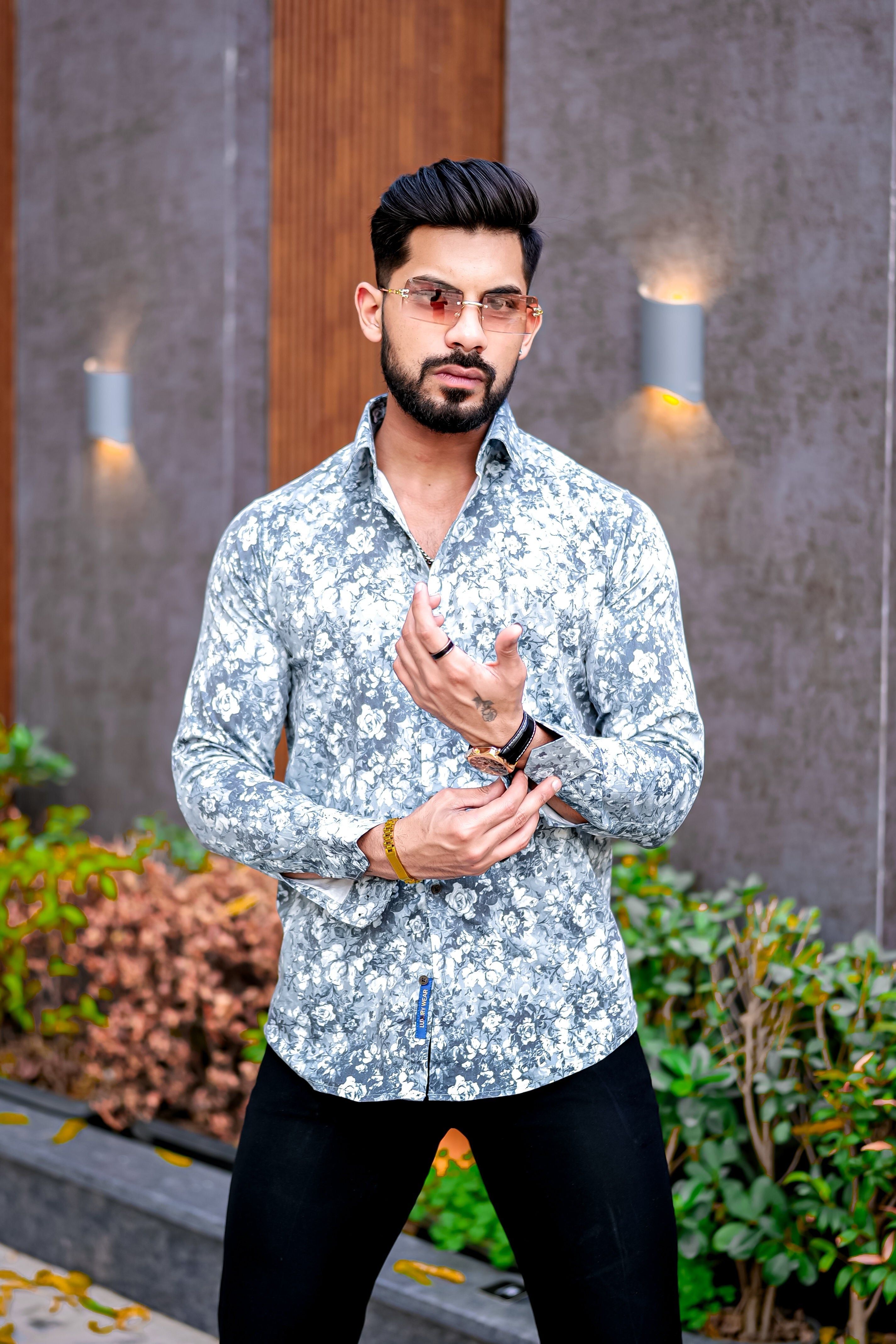 a man in a floral shirt and black pants