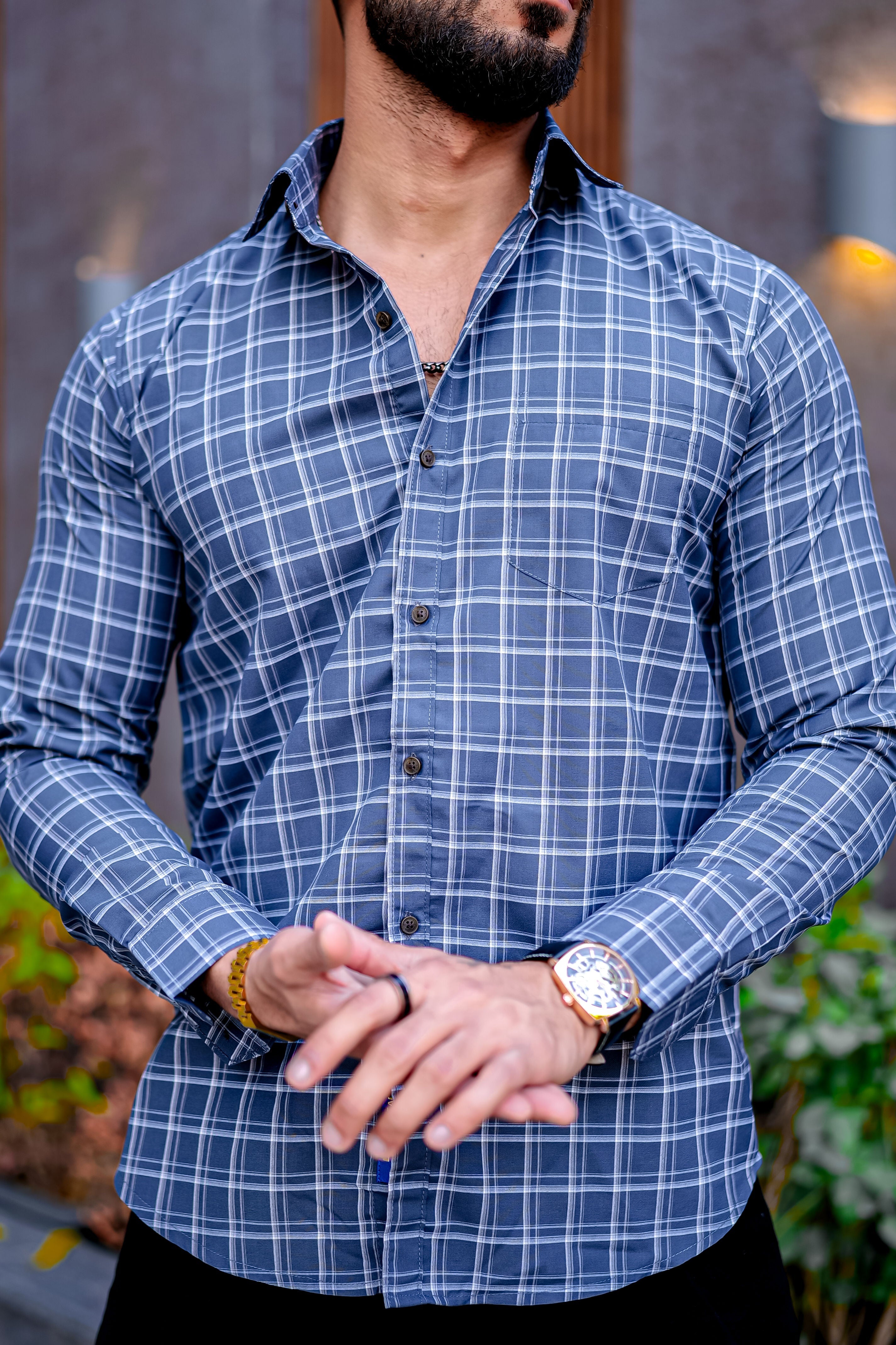 a man with a beard wearing a blue checkered shirt